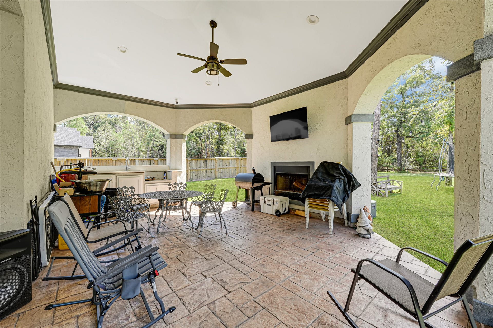 4210 Hidden Winds Drive, Spring, TX 77386 Covered rear patio with a ceiling fan offers space for outdoor seating and views of the backyard.