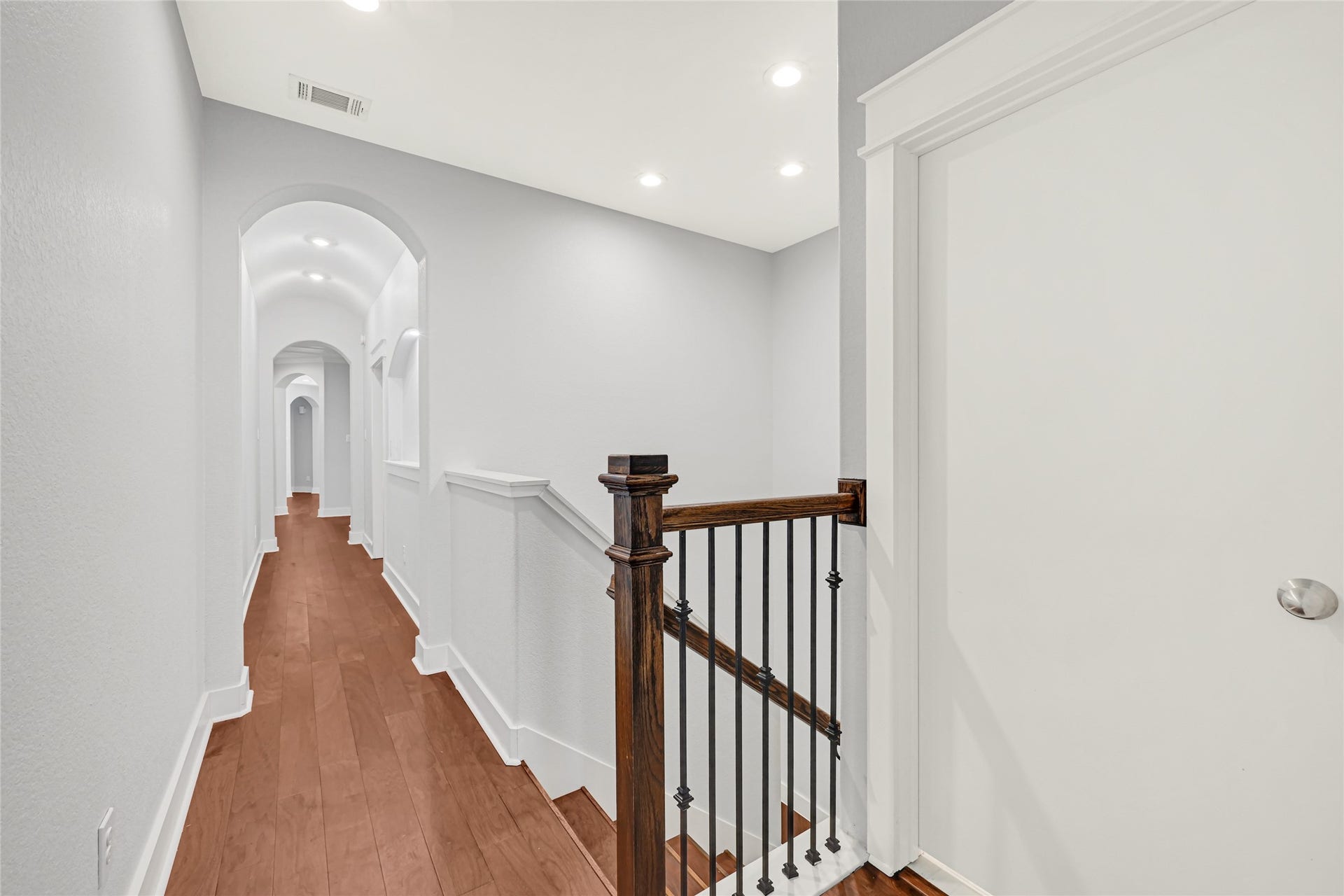 4210 Hidden Winds Drive, Spring, TX 77386 Upstairs hallway features wood flooring and decorative iron railing overlooking the staircase.