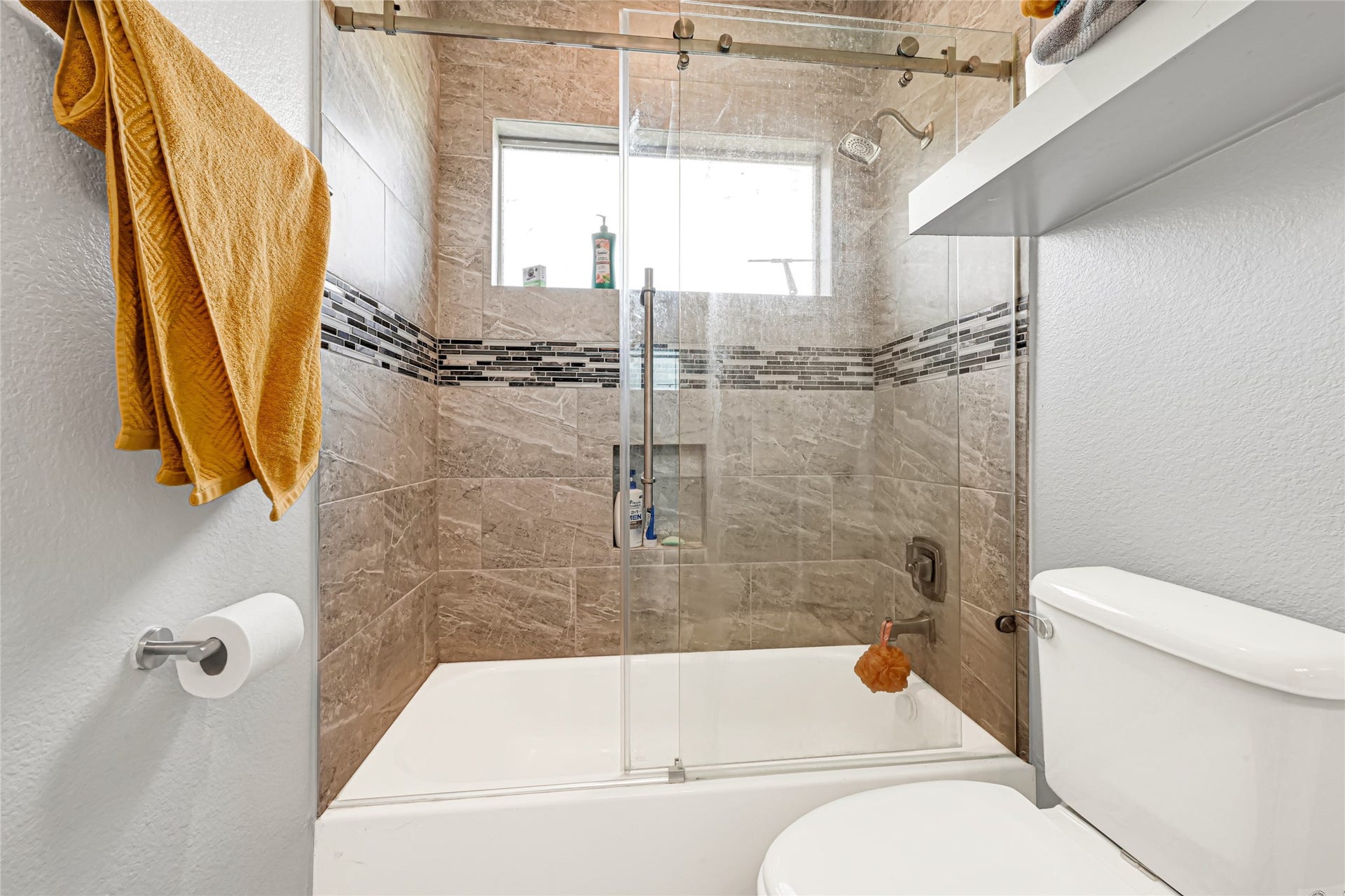 4210 Hidden Winds Drive, Spring, TX 77386 Tub and shower combination with tile surround and a window for natural light.