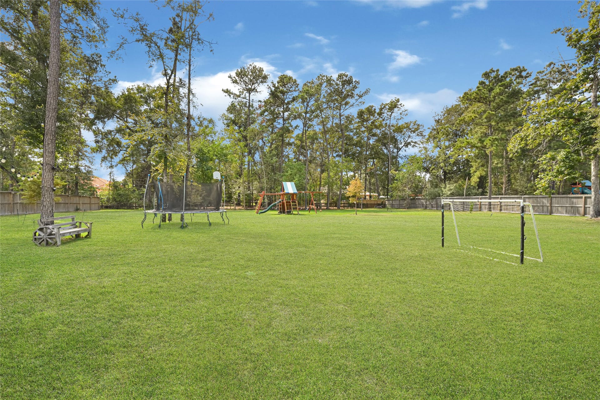 4210 Hidden Winds Drive, Spring, TX 77386 Expansive backyard offers open green space bordered by mature trees.