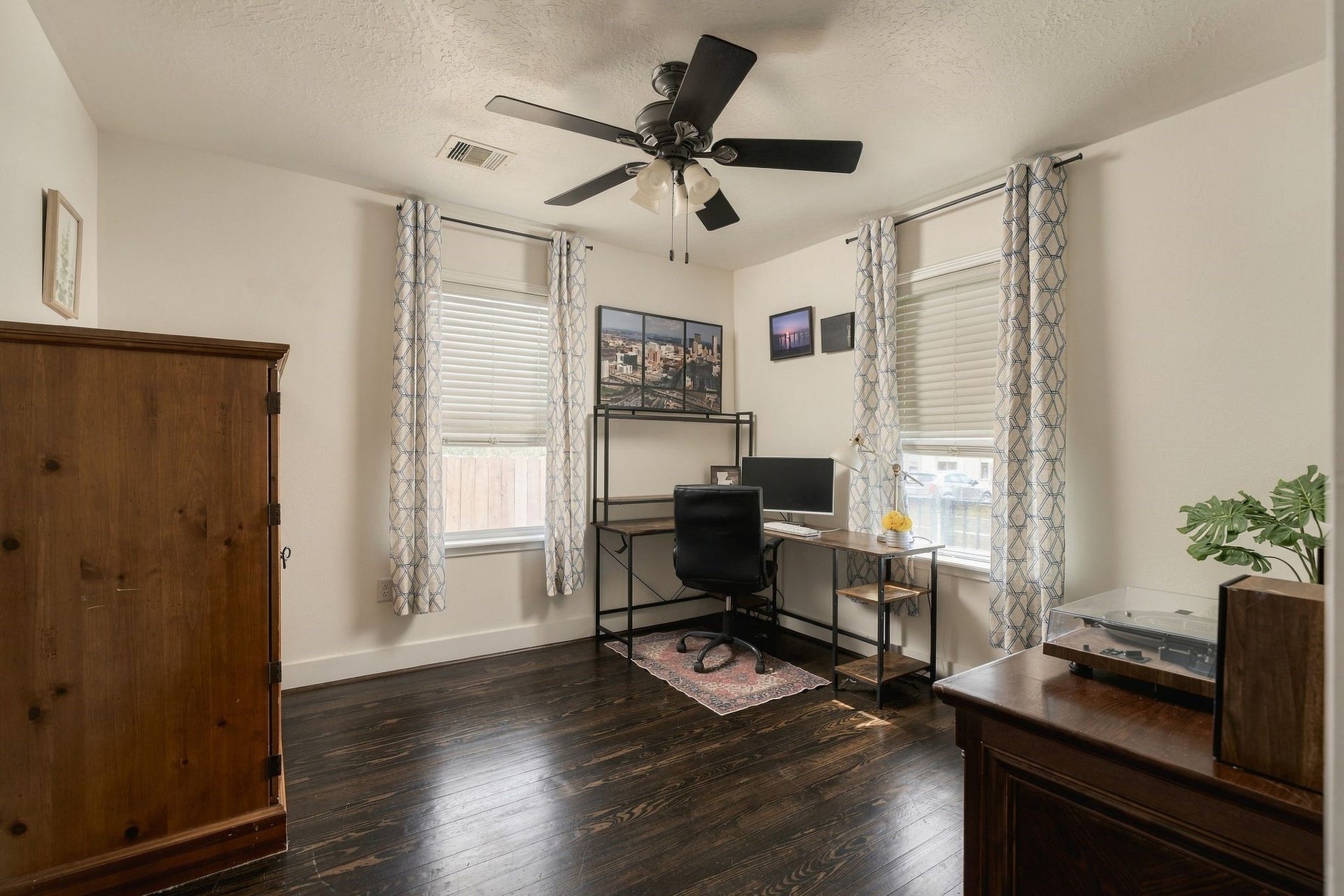 614 Coronado Street, Houston, TX 77009 Light-filled secondary bedroom with windows along two walls, currently arranged as a home office. An ideal flex space for working from home, accommodating guests, or creating a personal retreat.