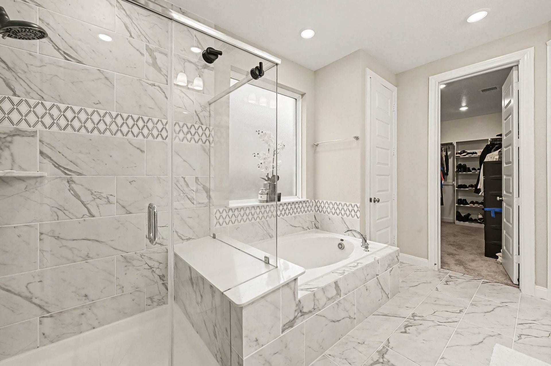 5107 Autumn Hills Trail, Pearland, TX 77584 Your Private Retreat Escape to a spa-inspired primary bath where beautiful tilework, a soaking tub, and glass-enclosed shower transform the everyday routine into a relaxing experience.