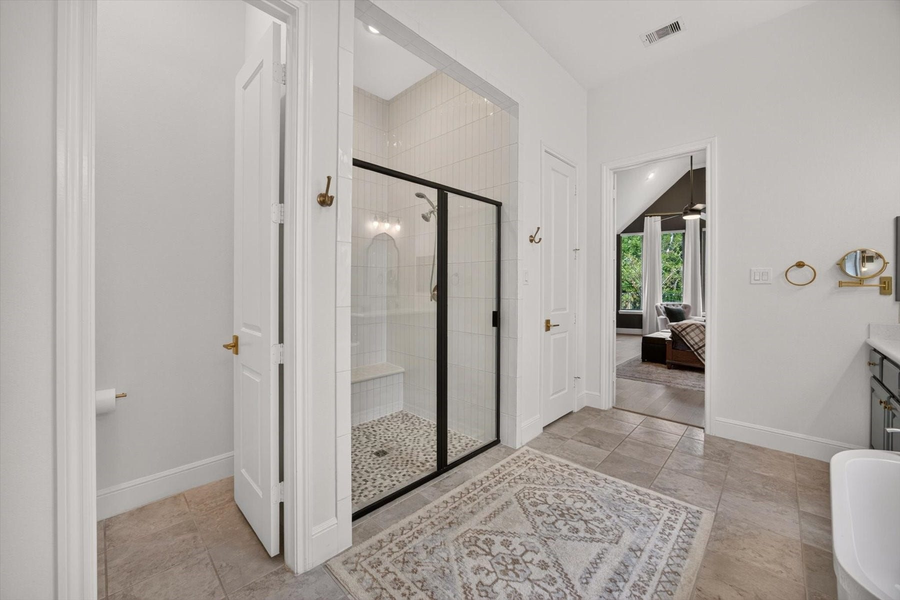 1219 Mcmurtry Ridge Drive, Katy, TX 77494 Spa-inspired bath featuring a spacious walk-in shower with a built-in bench and floor-to-ceiling tile, plus a separate private water closet for added comfort and convenience.