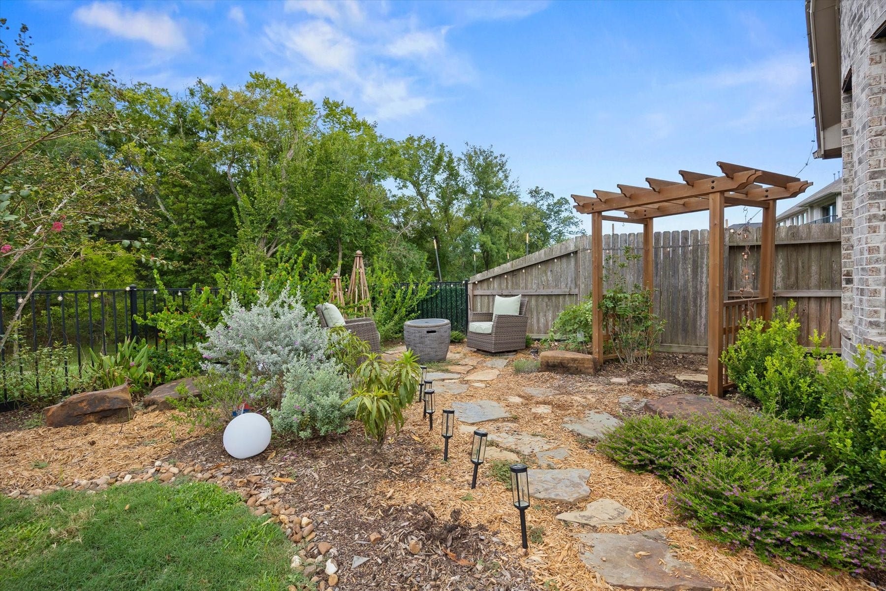 1219 Mcmurtry Ridge Drive, Katy, TX 77494 Serene backyard retreat featuring a beautifully landscaped rock garden and inviting sitting areaperfect for relaxing and enjoying the peaceful outdoor setting.