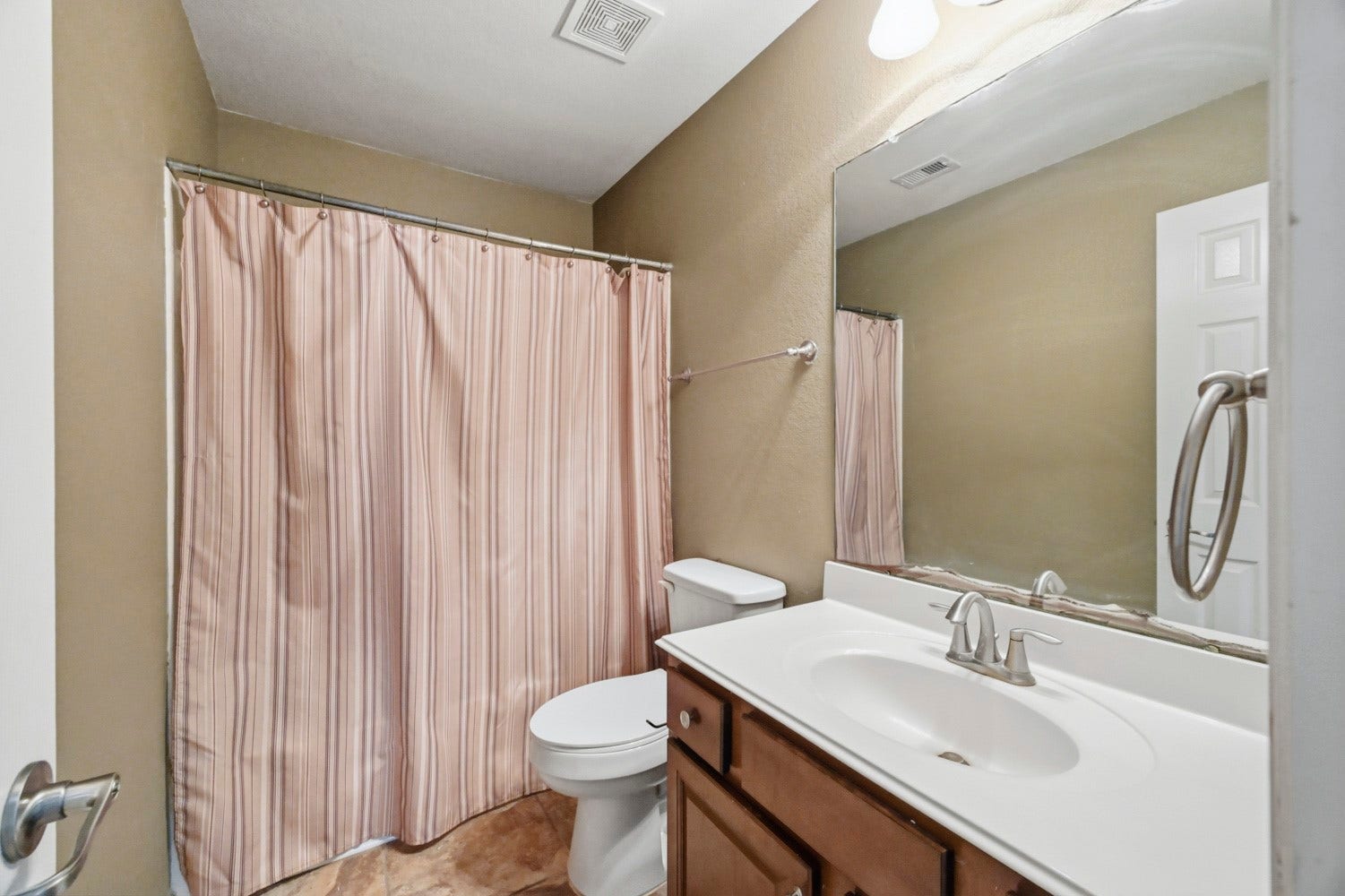 This clean secondary bath provides ideal utility for family members and guests alike. Highlights include a full shower/tub combo, a spacious vanity sink with lower storage drawers.