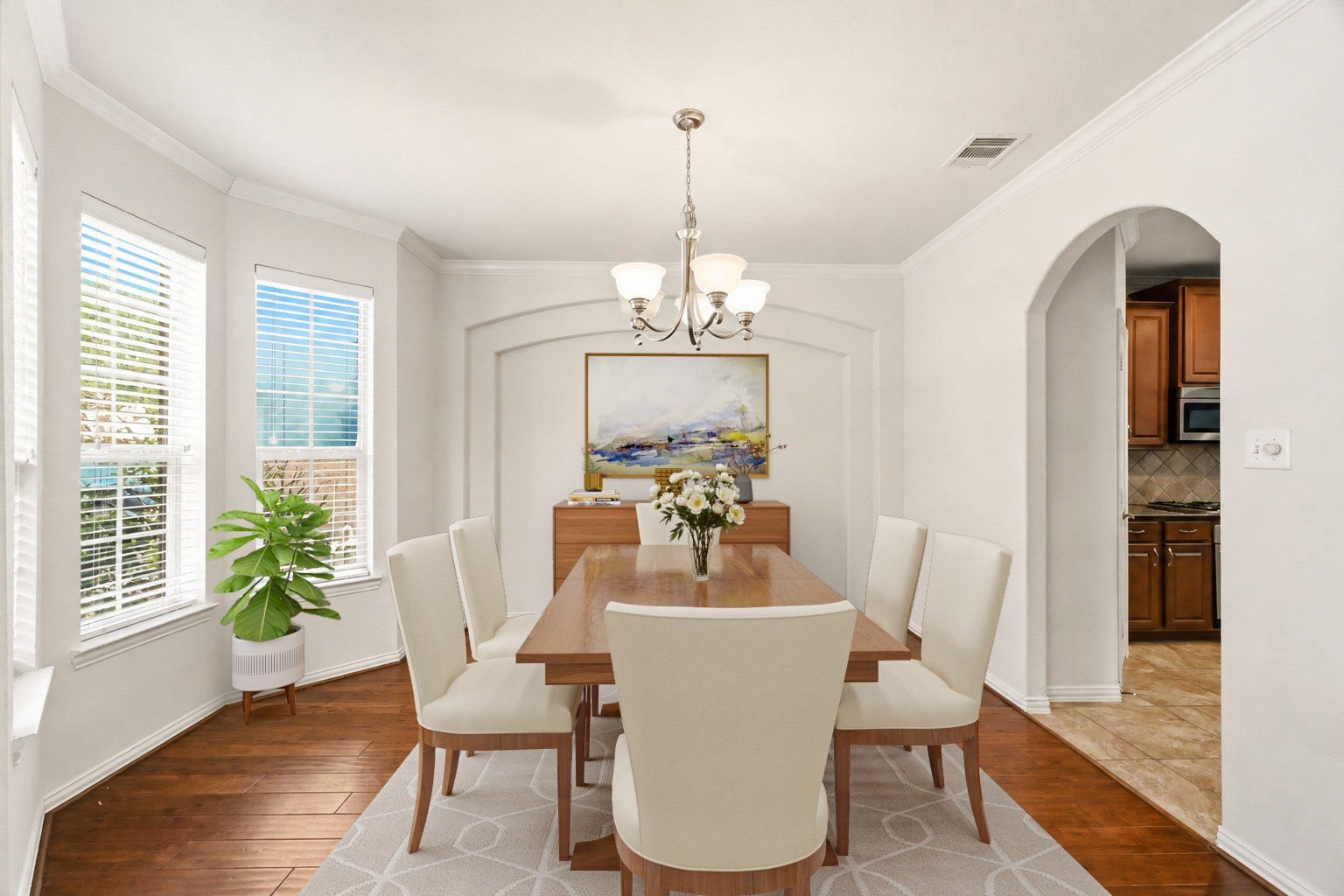 Virtually Staged: A lovely bay window alcove bathes the room in soft natural light, while crown molding and an elegant central chandelier elevate the design.