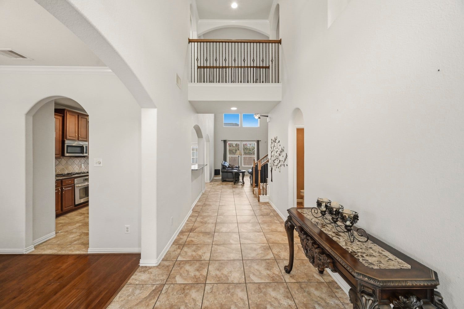 Step inside this inviting entrance, where towering ceilings and sweeping architectural arches create an immediate sense of warmth and space.