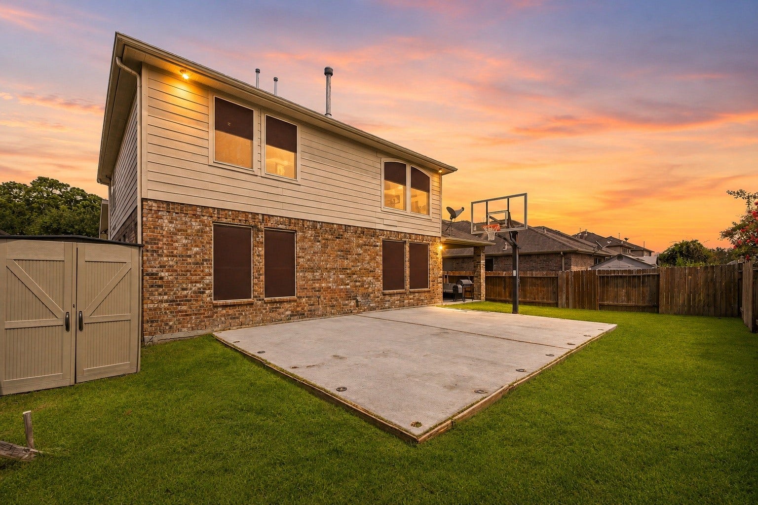 Showcasing another angle of this impressive backyard retreat, this view highlights the full extent of the custom concrete sport court with its integrated basketball hoop.