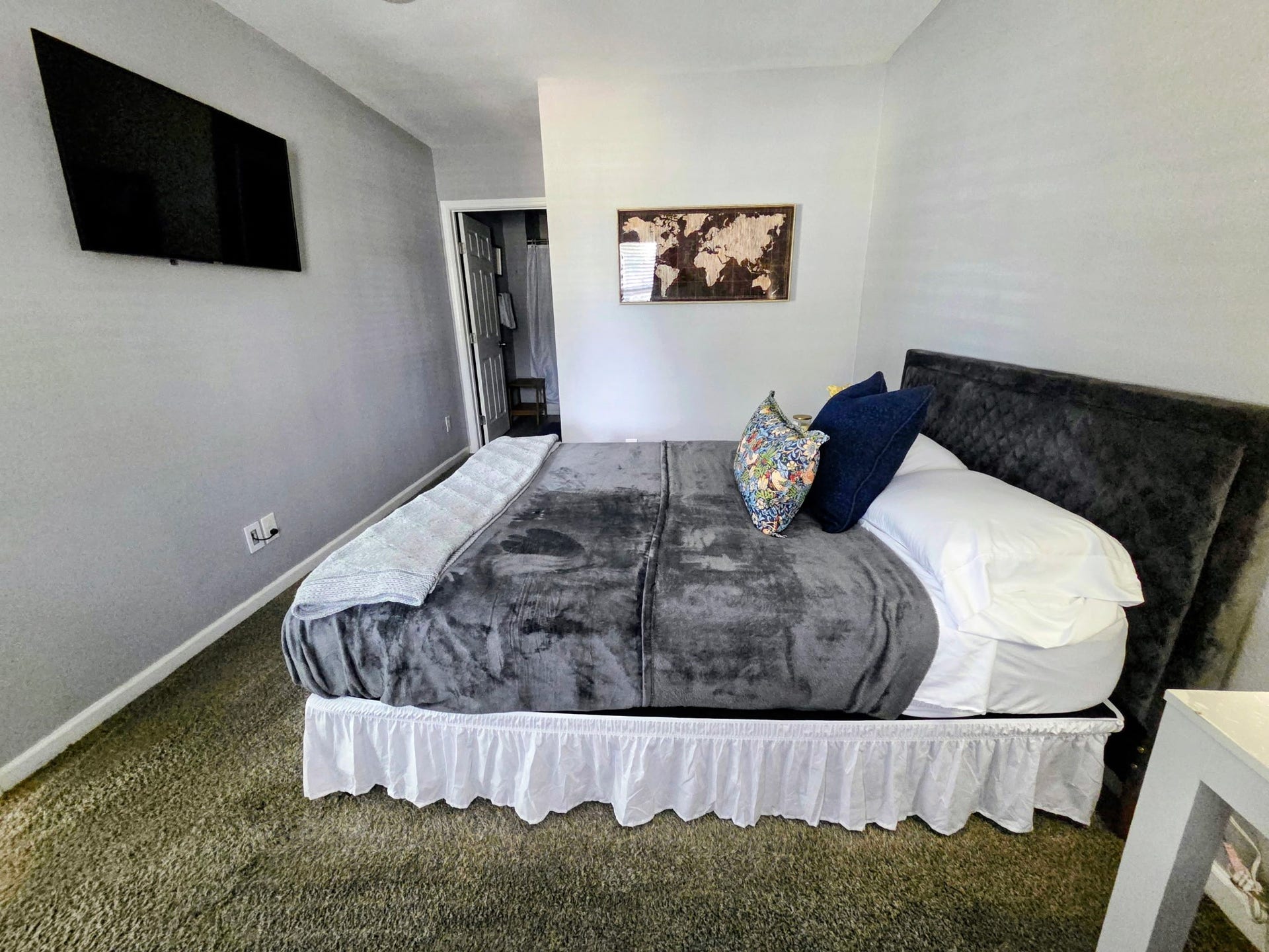 Nice primary bedroom with an oversize bed and a mounted TV.