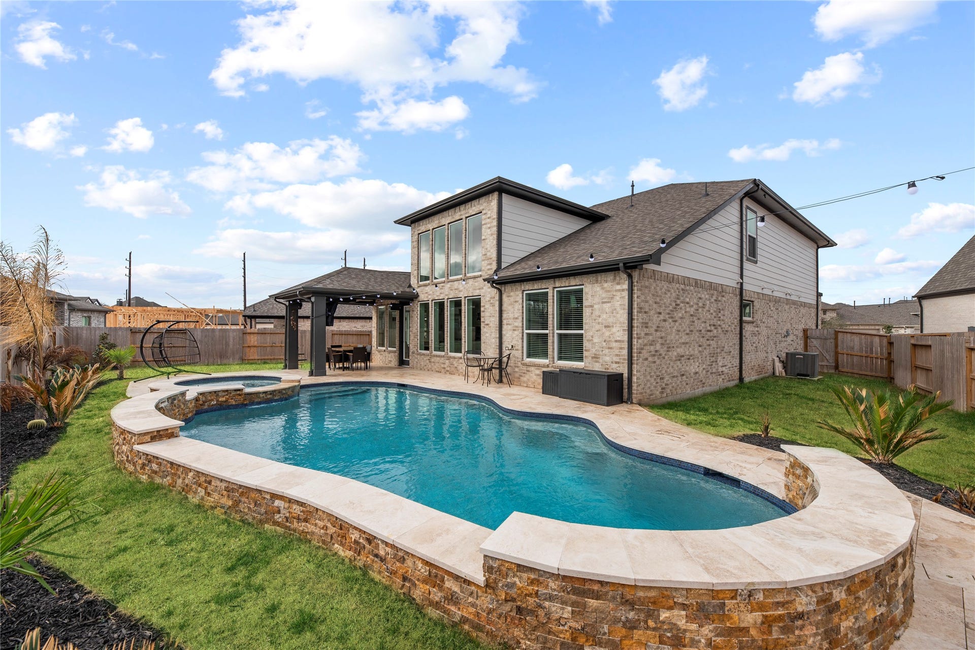 Step into the backyard oasis, where a sparkling pool with smartphone controls and a large yard create an inviting space to relax and enjoy sunny days.
