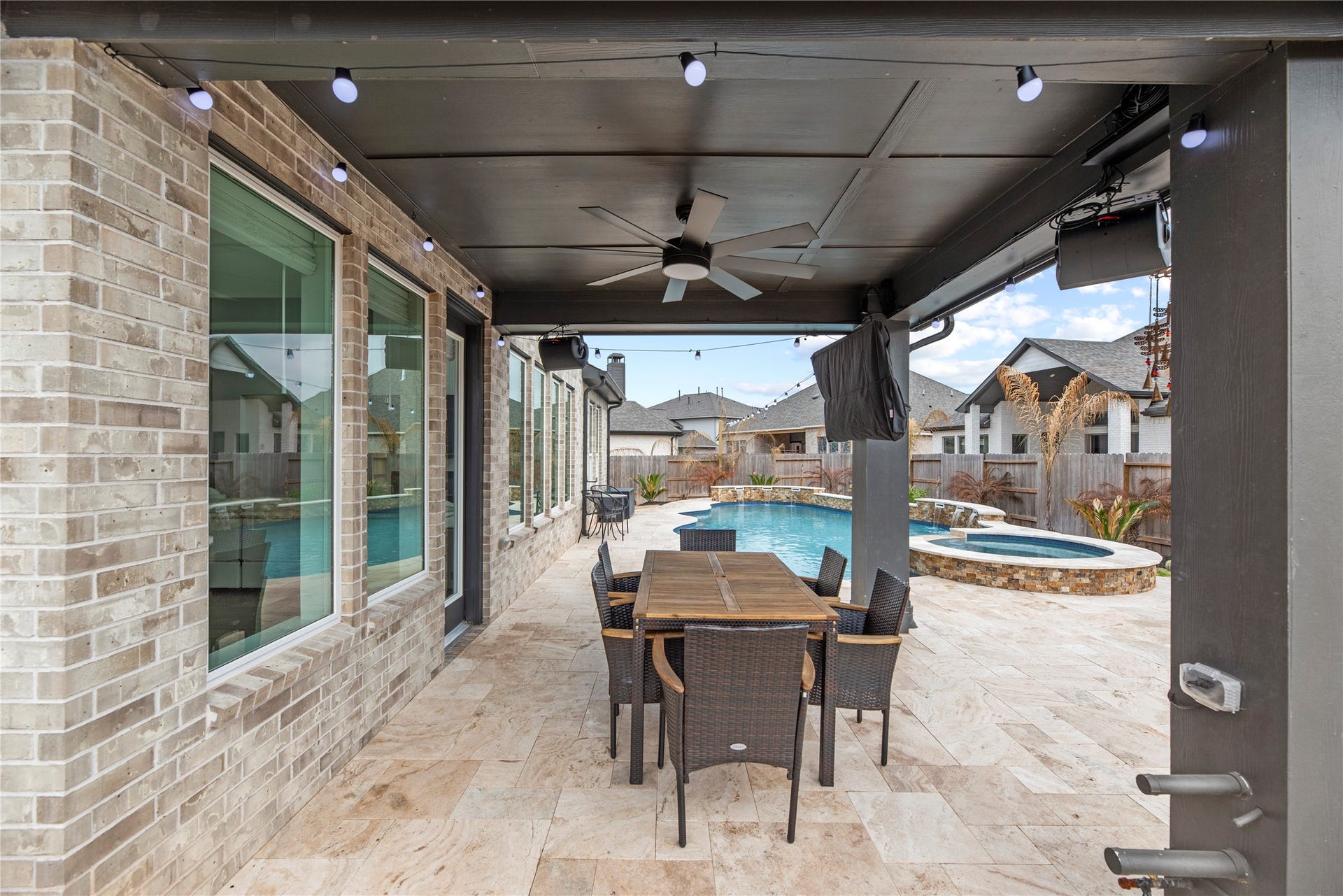 The extended covered patio offers plenty of space for a lounge setup or outdoor dining, creating a versatile area to enjoy the backyard. There is a natural gas line available for your grill!