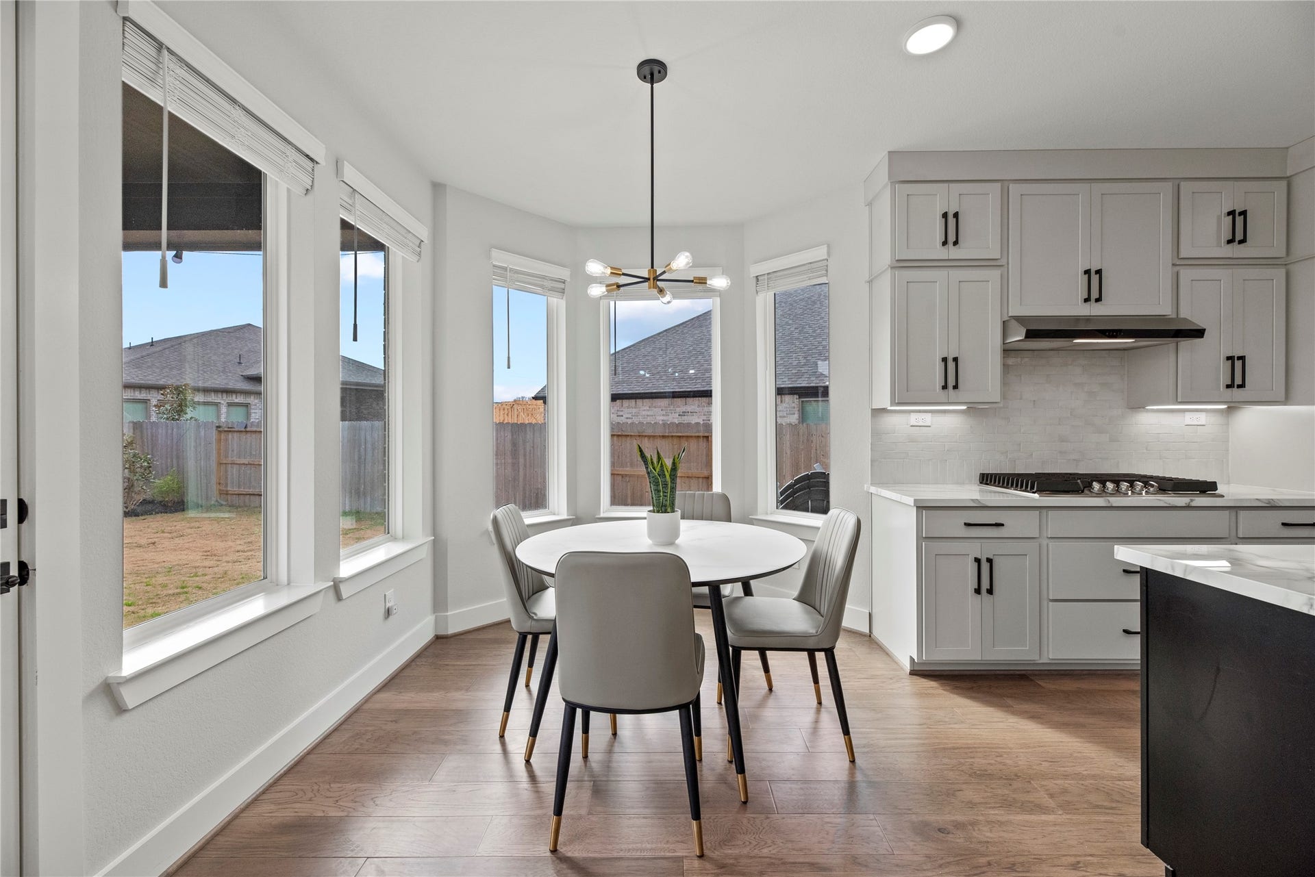 The breakfast room is ideal for a full-sized table and features gorgeous large bright windows overlooking the picturesque backyard and lovely overhead chandelier.