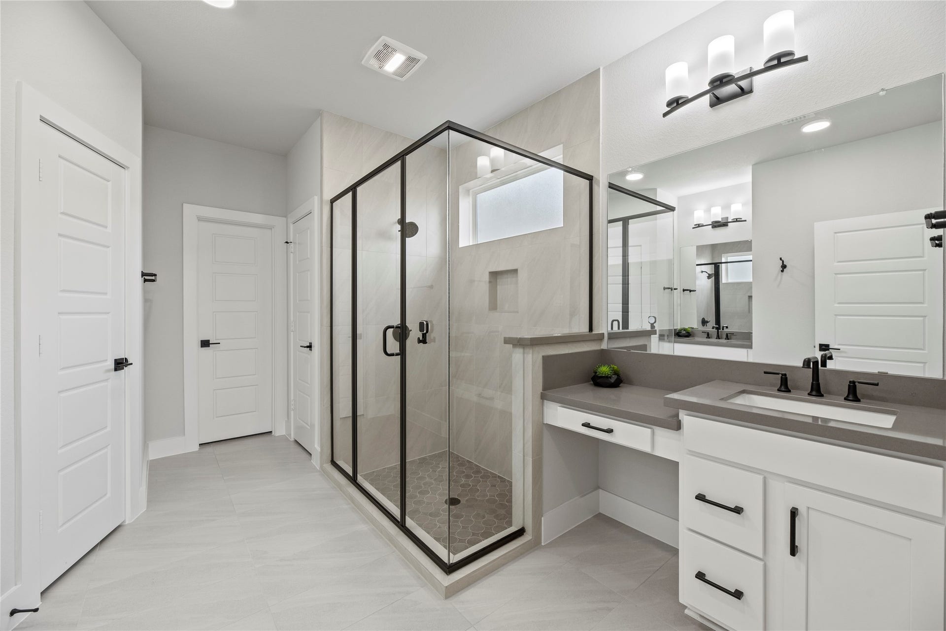 Step into your private bathroom with an oversized glass-enclosed shower with beautiful tile work throughout.