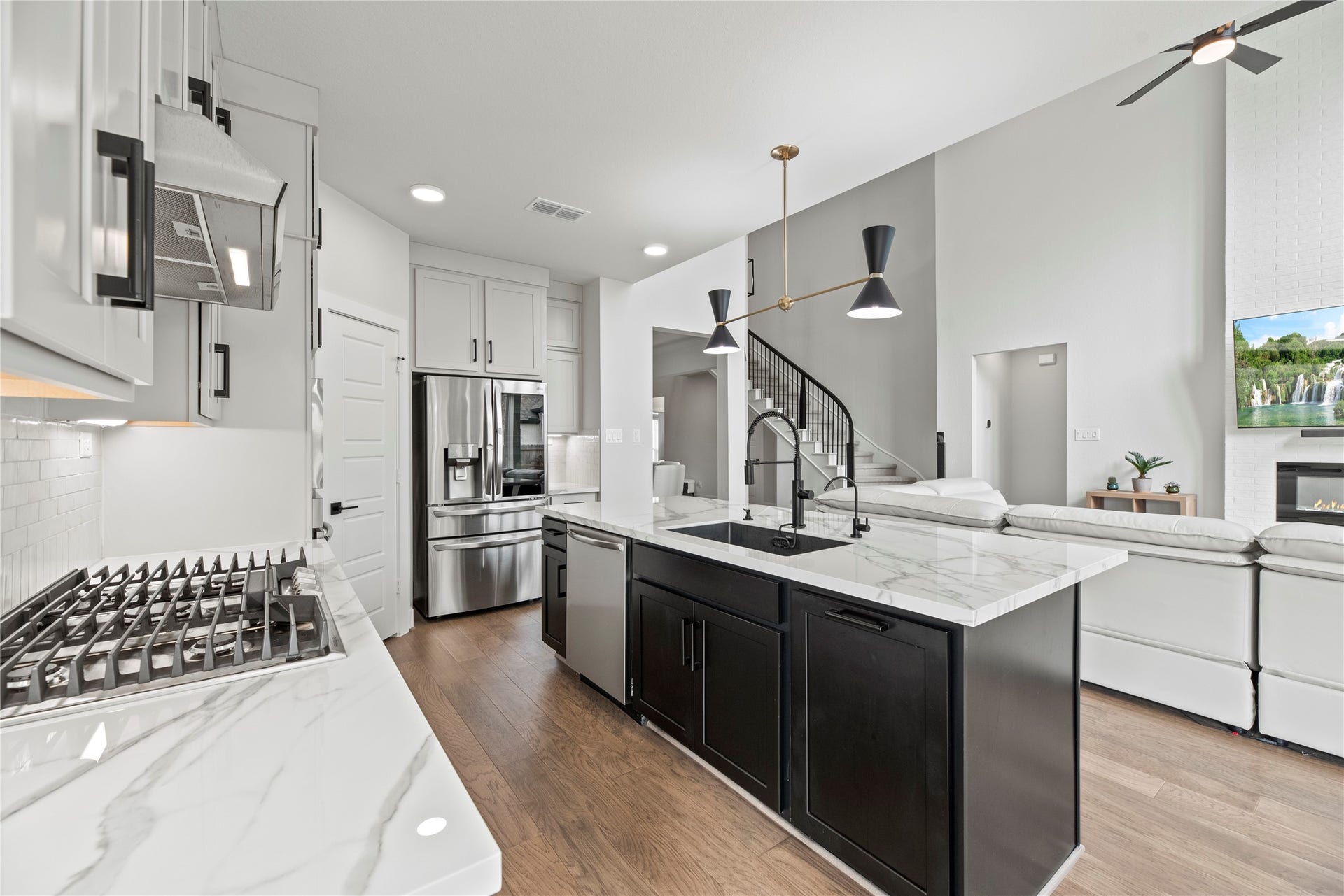 Stainless steel appliances anchor the kitchen, featuring a large gas range with a matching vent hood, a built-in dishwasher, and an undermount sink, creating a well-planned space that supports both daily cooking and entertaining.