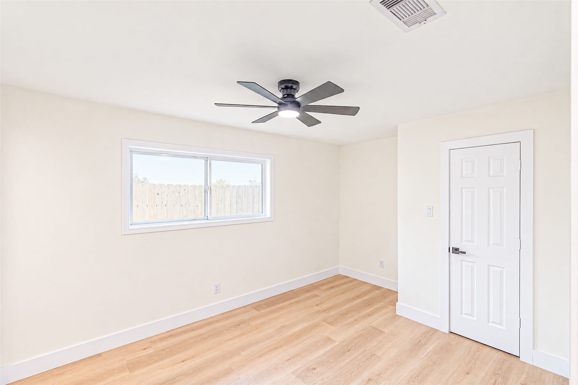 Elegant and airy, bedroom 3 features sleek hardwood floors, a modern ceiling fan, and abundant natural light.