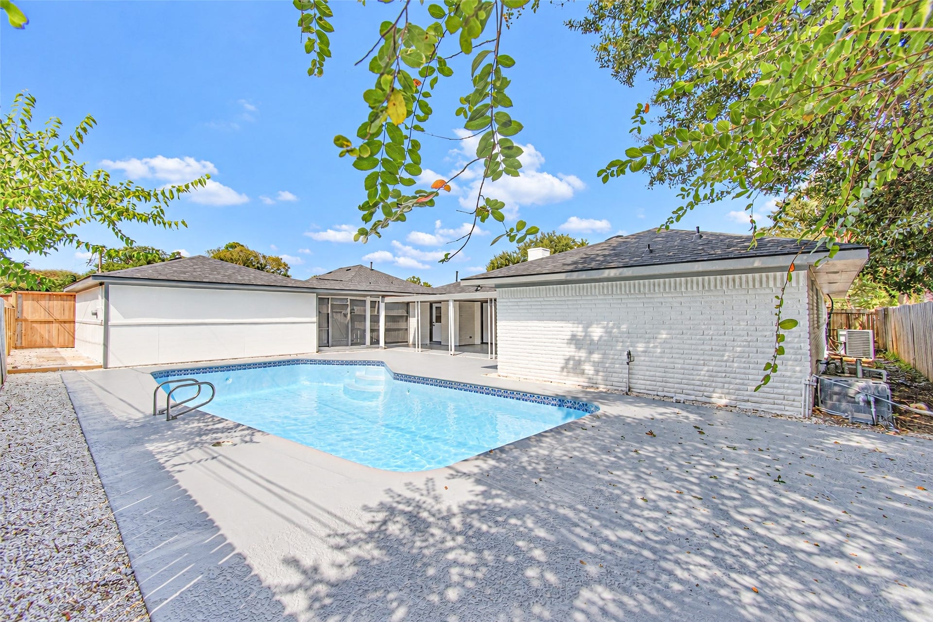 Charming backyard oasis featuring a sparkling swimming pool and spacious patio, perfect for outdoor entertaining and relaxation.