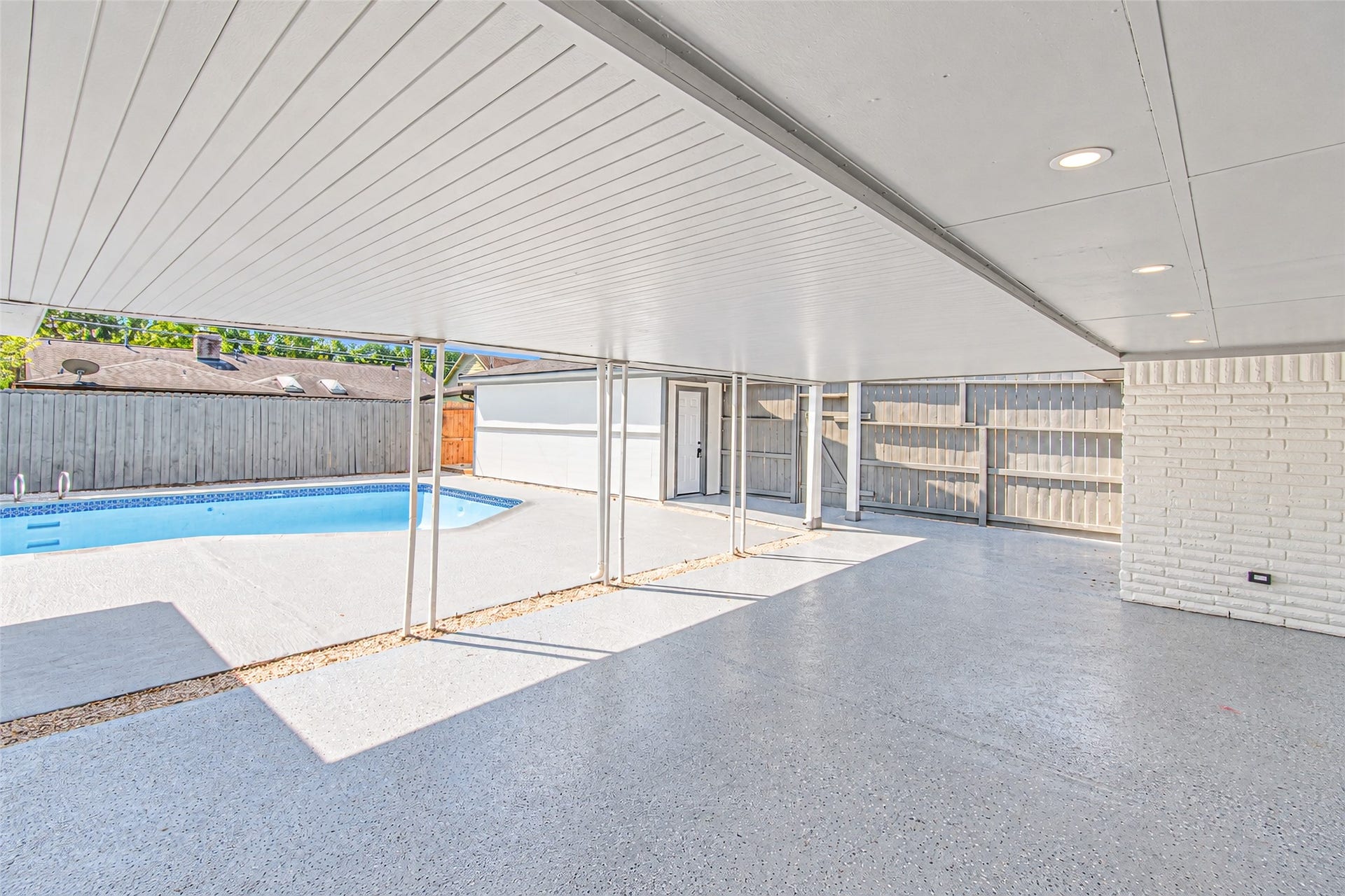 Enjoy outdoor living with this spacious covered patio, perfect for relaxation and entertaining by the pool.