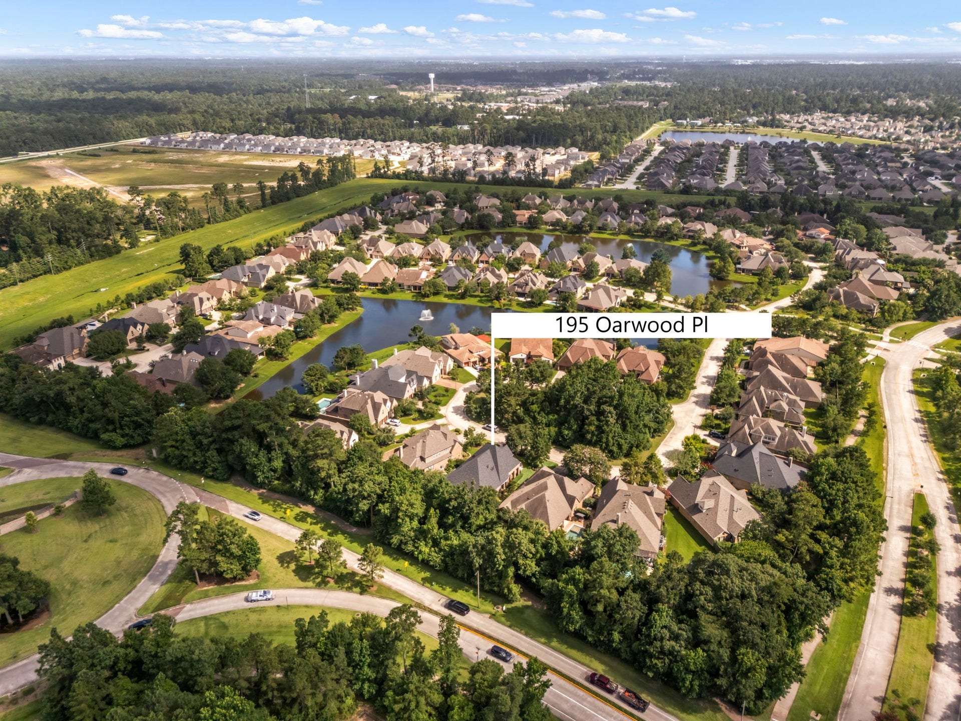 195 Oarwood Place, The Woodlands, TX 77389 This spectacular aerial perspective captures the highly desirable, master-planned enclave layout surrounding the property. Nestled within a private loop and bordered by lush, mature greenbelts, the masterfully designed neighborhood features serene community lakes and beautifully manicured common areas. Enjoy a quiet, picturesque setting with wide, pedestrian-friendly streets, minimal local traffic, and unparalleled proximity to premier local shopping and dining districts.