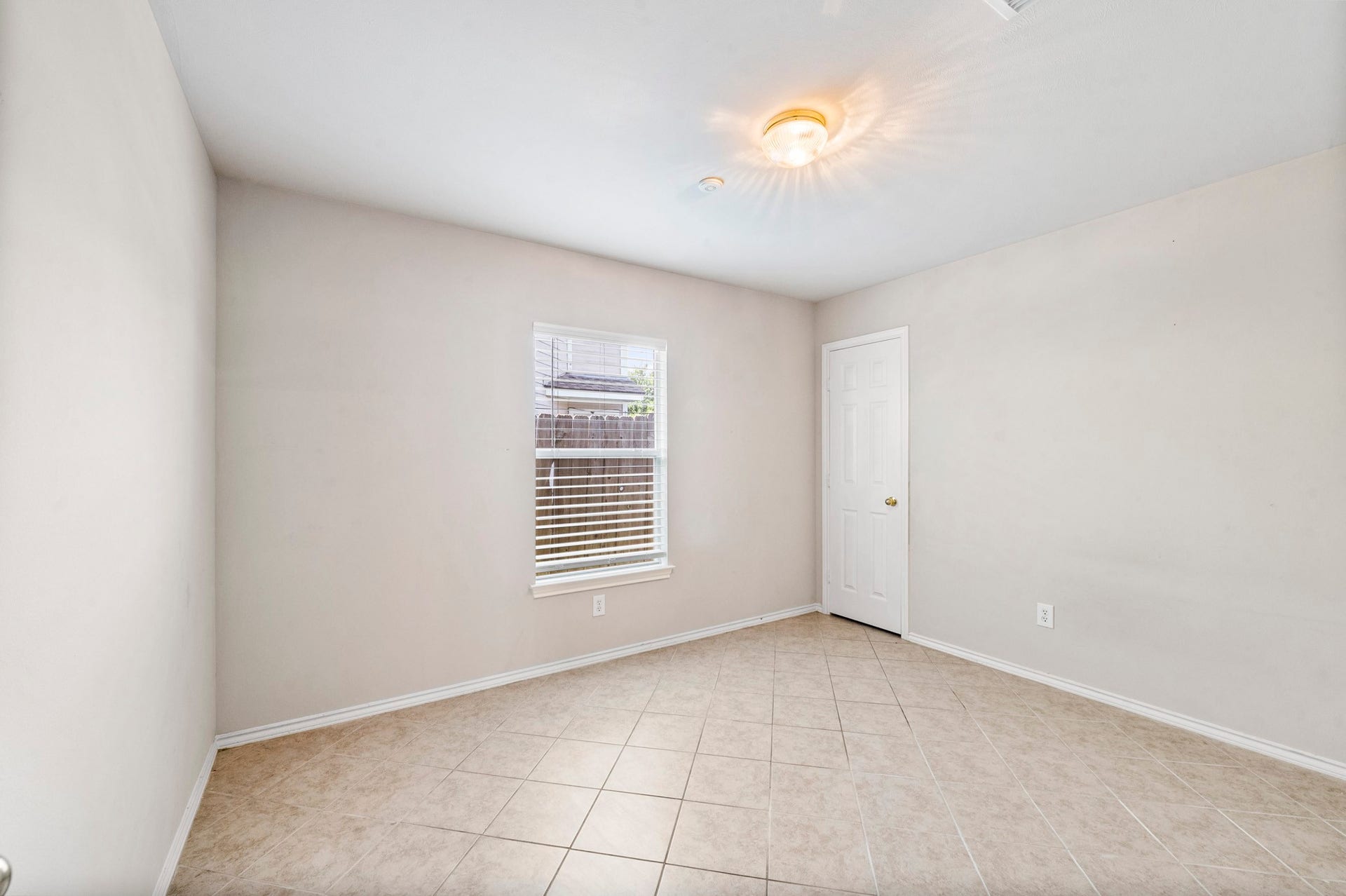 6322 Sunlit Orchard Drive, Houston, TX 77072 Bright and inviting room with neutral walls, tile flooring, and ample natural light from the window, perfect for flexible use.