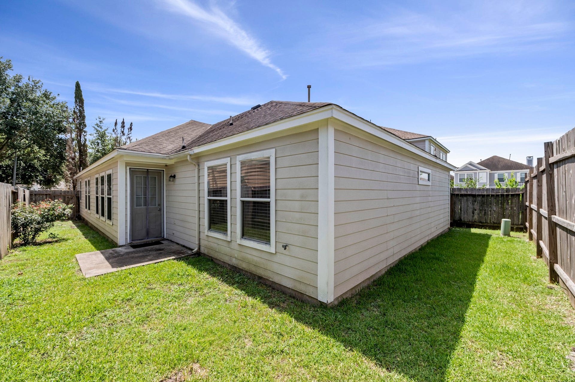 6322 Sunlit Orchard Drive, Houston, TX 77072 Cozy backyard retreat with a well-maintained lawn, privacy fencing, and ample sunlight, perfect for relaxing or entertaining.