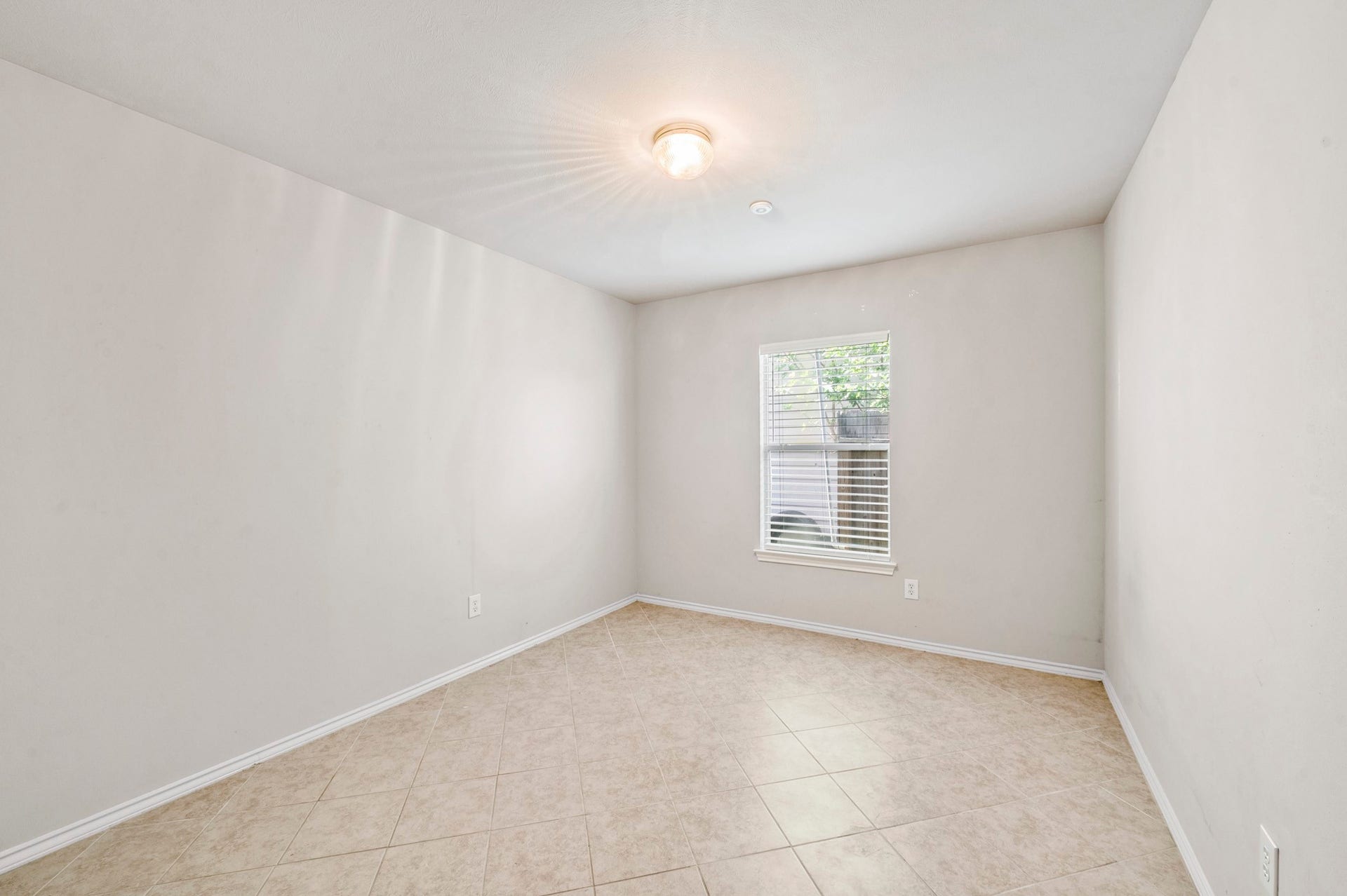 6322 Sunlit Orchard Drive, Houston, TX 77072 Bright and airy room featuring neutral walls and a large window, perfect for a cozy bedroom or home office.