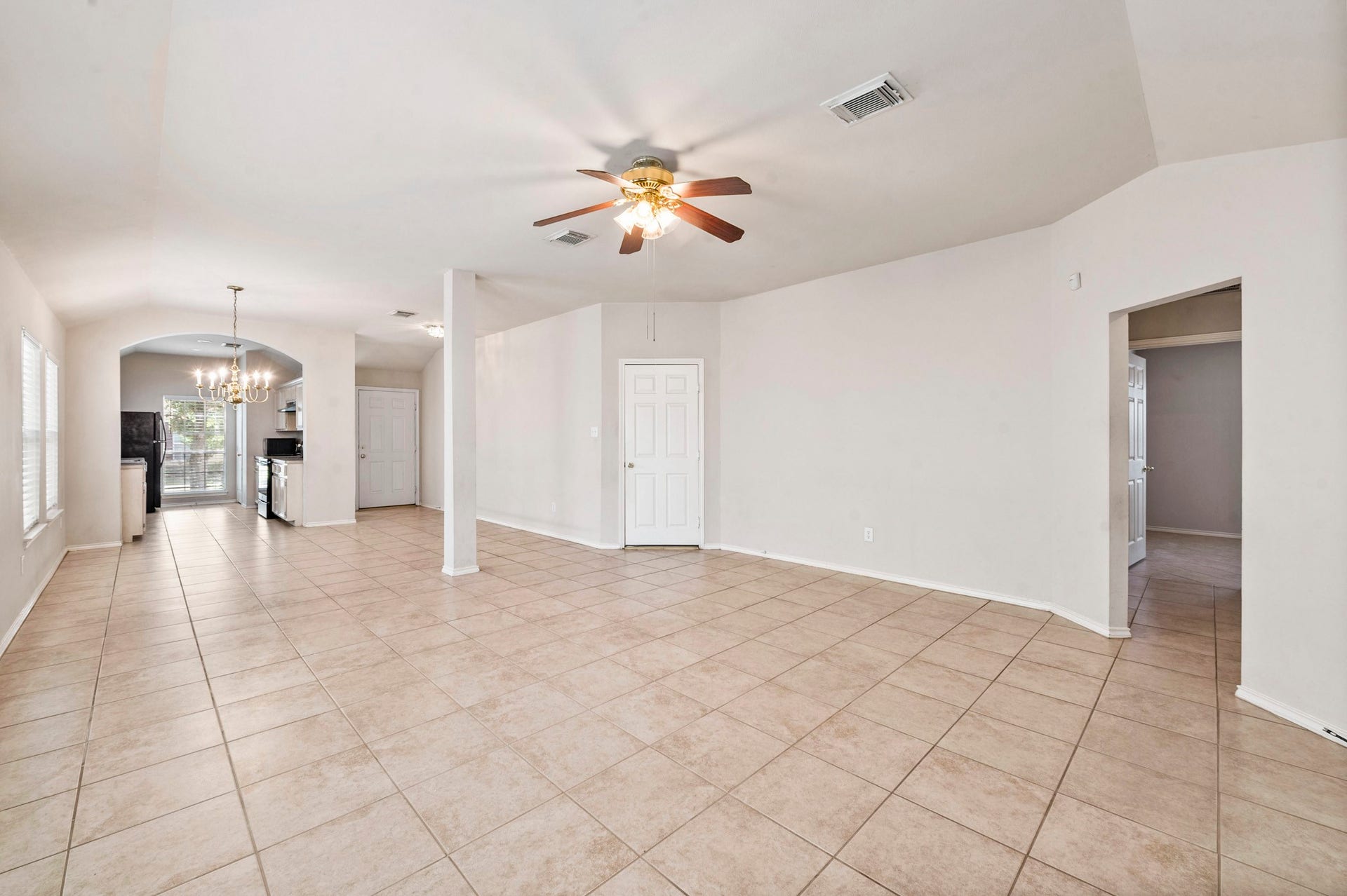 6322 Sunlit Orchard Drive, Houston, TX 77072 Spacious open-concept living area with tile flooring, ceiling fan, and abundant natural light, seamlessly connecting to the dining area and kitchen.