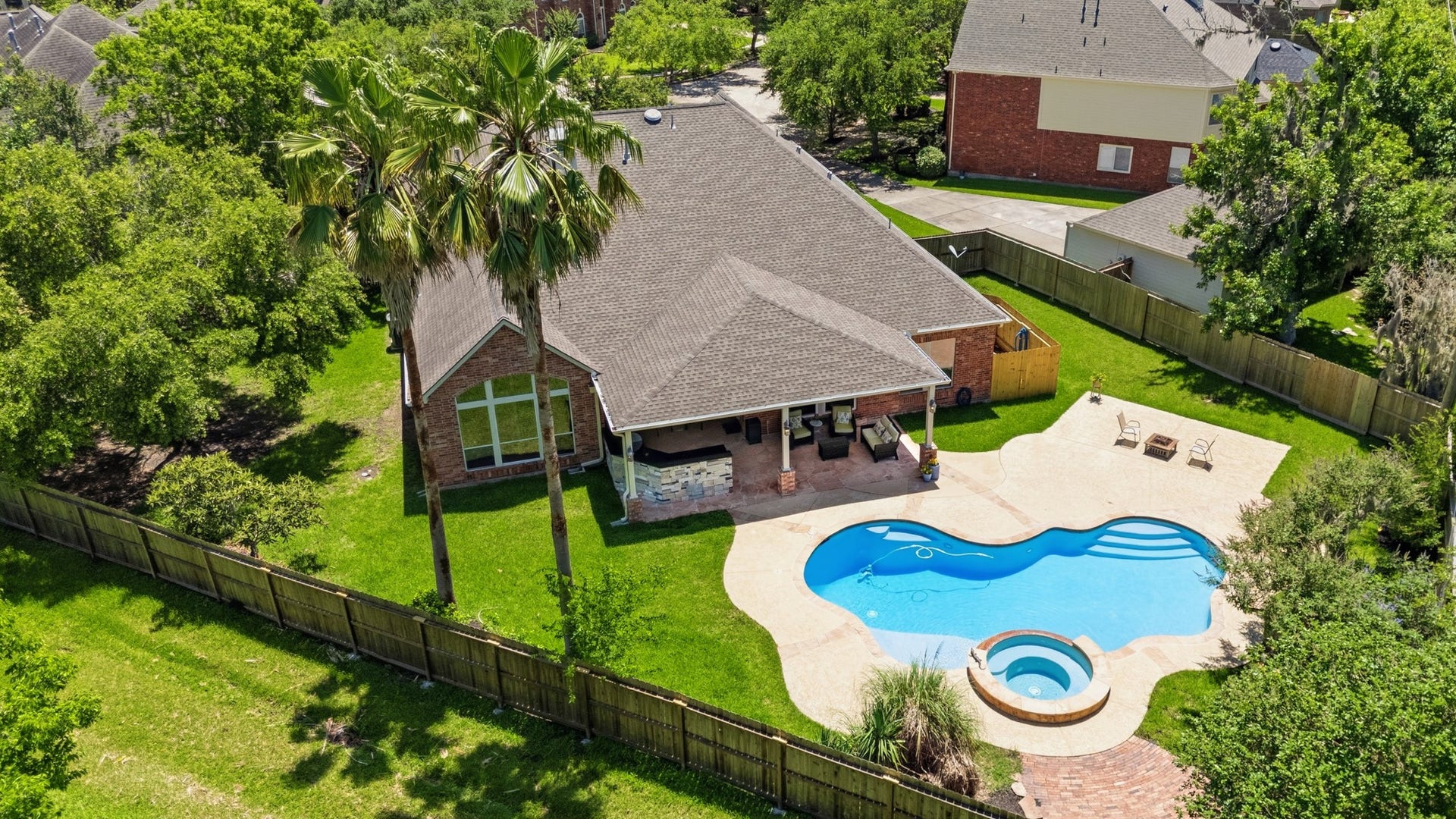 8902 Dakota Court, Missouri City, TX 77459 Presenting 8902 Dakota Ct with nearly 16,000 sqft of private outdoor living, framed by mature trees and anchored by a pool, spa, covered patio, and outdoor kitchen.