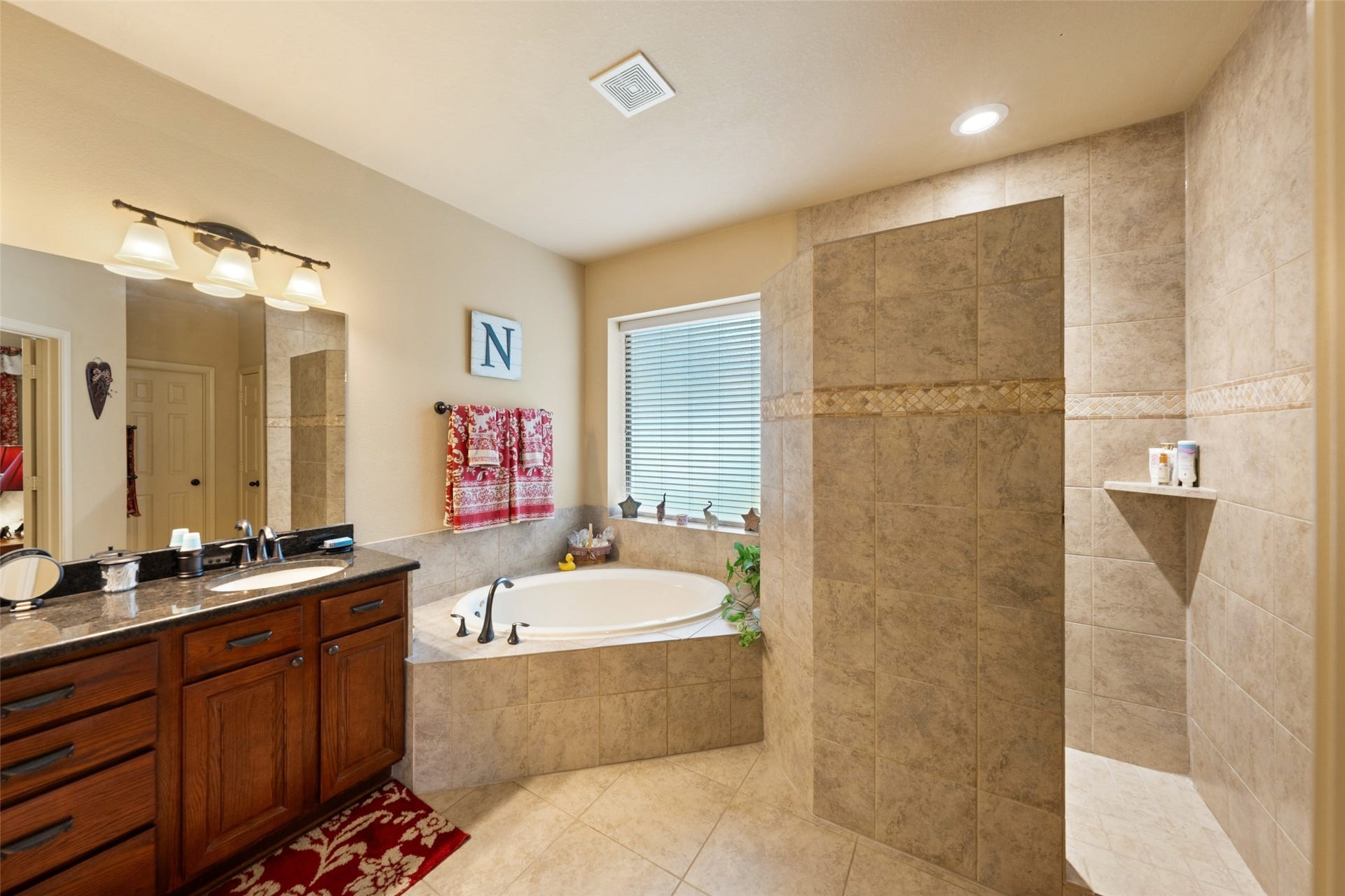 903 Weeping Willow Way, Magnolia, TX 77354 Spacious bathroom features a walk-in custom shower that is all tile offering privacy and freedom from using squeegee on a glass enclosure. The raised vanity also offers great storage options