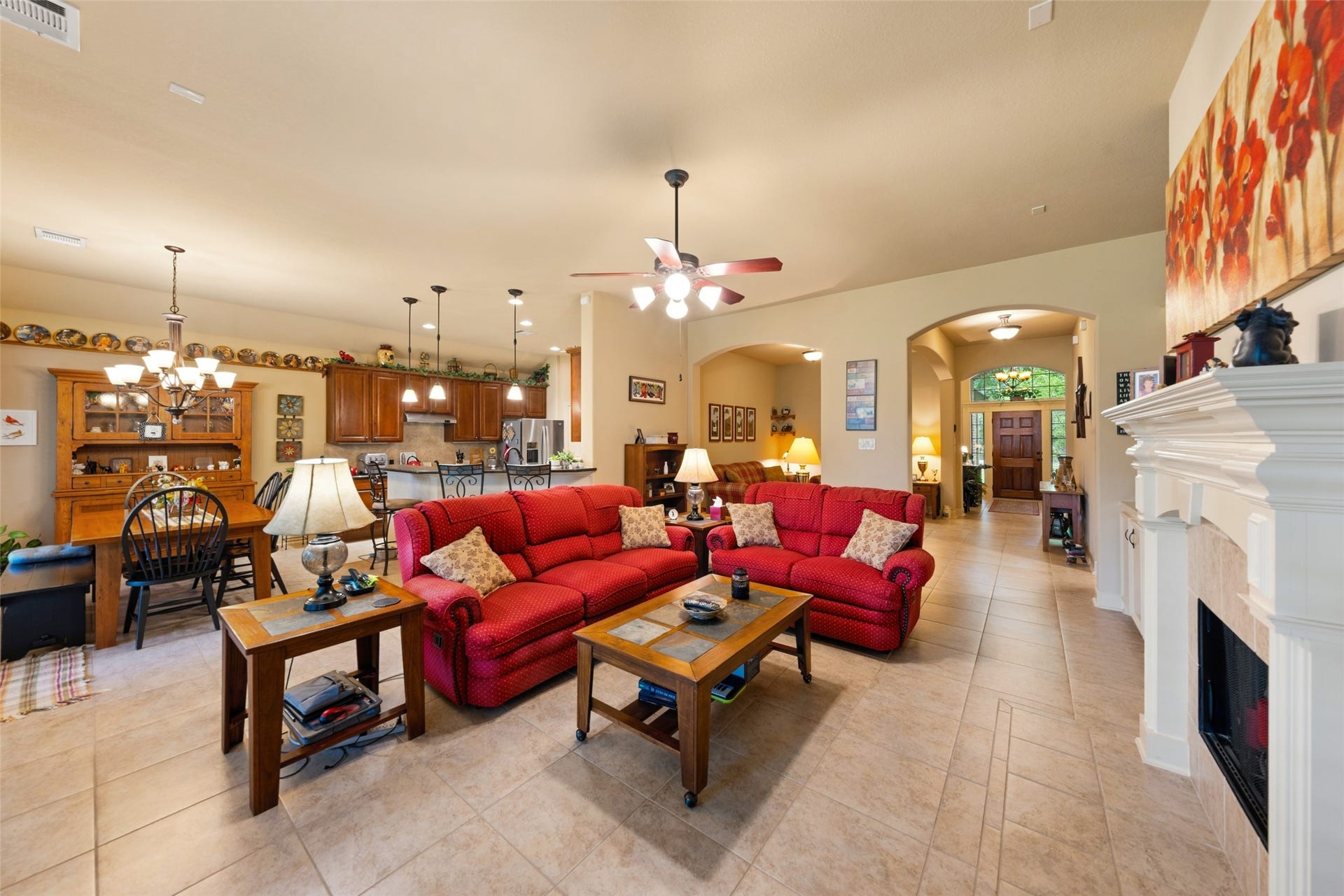 903 Weeping Willow Way, Magnolia, TX 77354 Spacious open-concept living area seamlessly flows into a modern kitchen with warm wooden cabinetry and a dining area, perfect for entertaining.