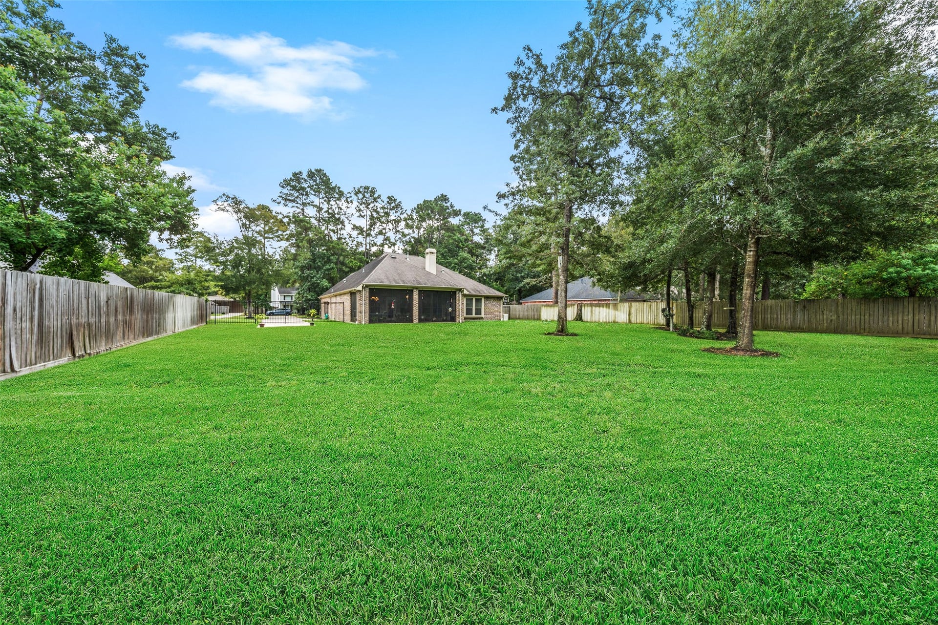 903 Weeping Willow Way, Magnolia, TX 77354 Expansive backyard with mature trees offering ample space for outdoor activities and privacy.