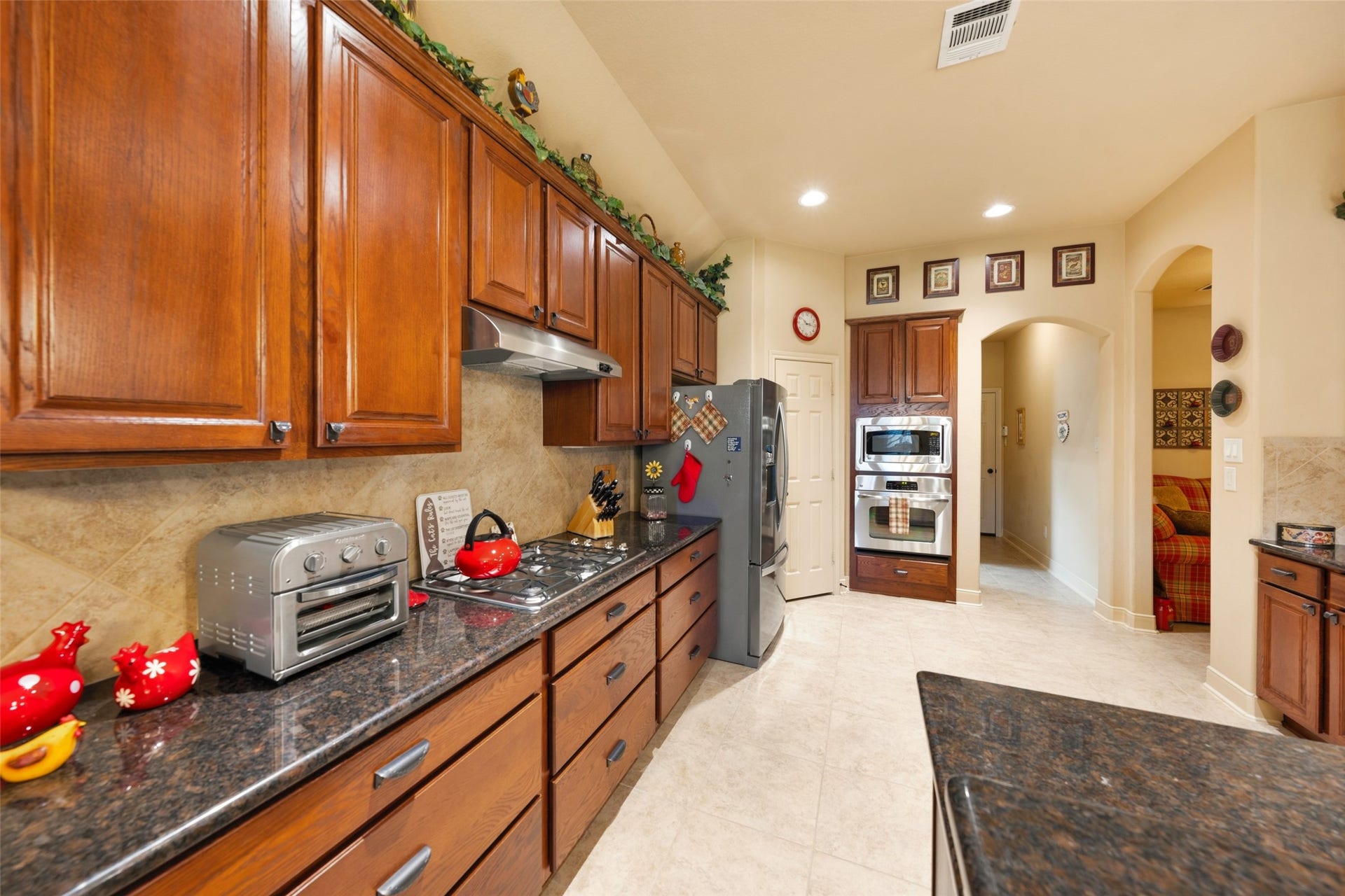 903 Weeping Willow Way, Magnolia, TX 77354 Spacious kitchen with rich wood cabinetry, sleek countertops, and modern stainless steel appliances, offering ample storage and a stylish, functional cooking space.