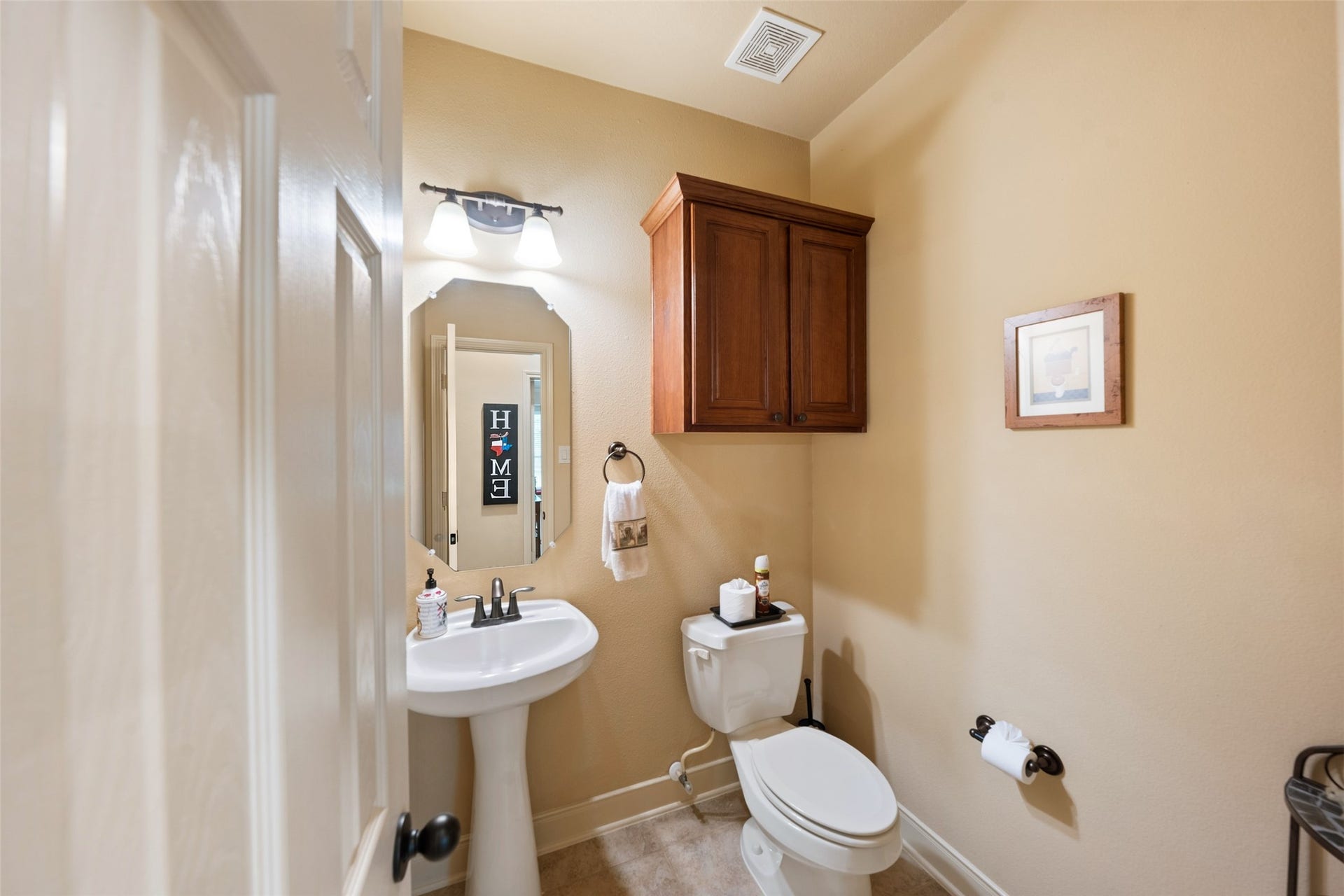 903 Weeping Willow Way, Magnolia, TX 77354 Powder room with a pedestal sink and cabinetry for added storage.
