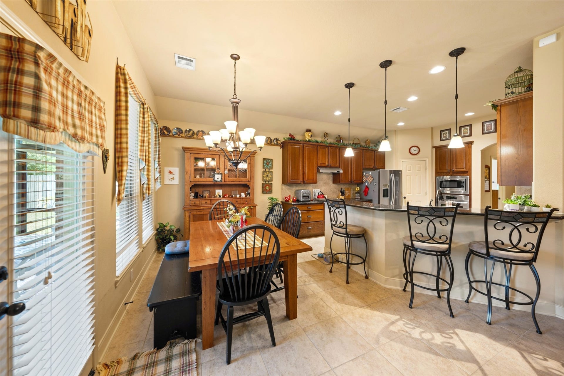 903 Weeping Willow Way, Magnolia, TX 77354 Spacious kitchen and dining area featuring warm wood cabinetry, bar seating and is open to living area.