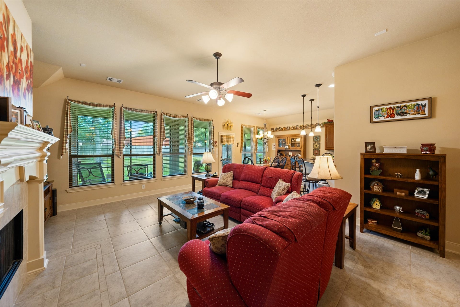 903 Weeping Willow Way, Magnolia, TX 77354 Spacious living area with large windows, tiled floors, seamlessly flowing into a dining and kitchen space