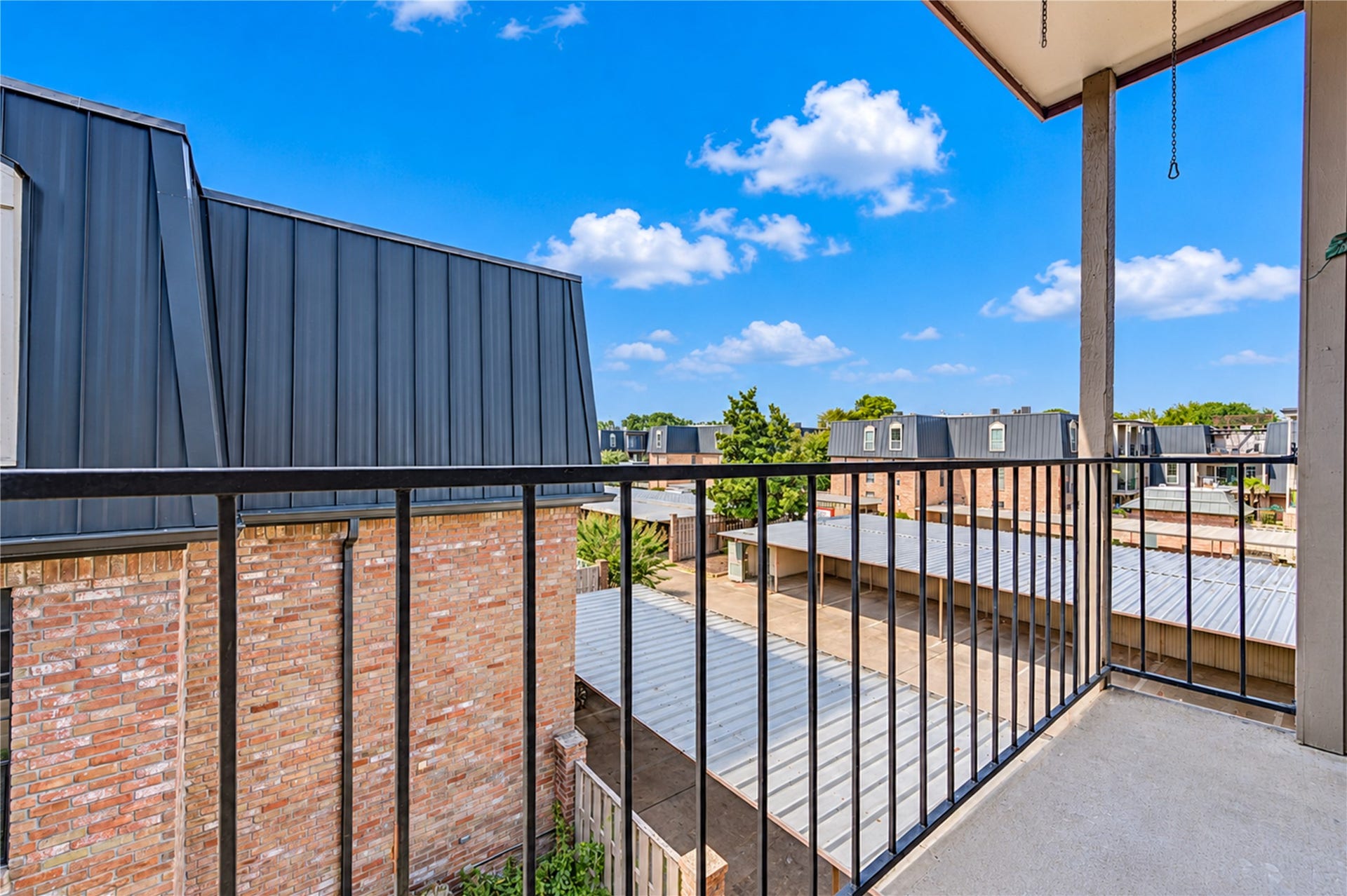 Charming brick courtyard with lush greenery and a cozy patio area, perfect for outdoor relaxation.
