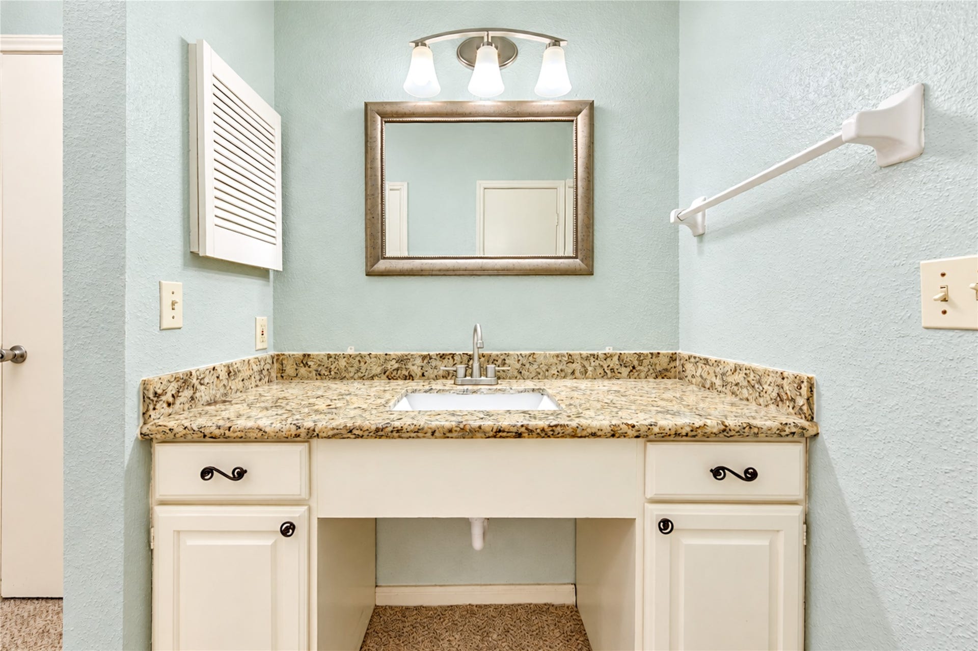 Bright bathroom featuring a classic white tiled shower and tub, accented with charming artwork and a sleek towel bar.