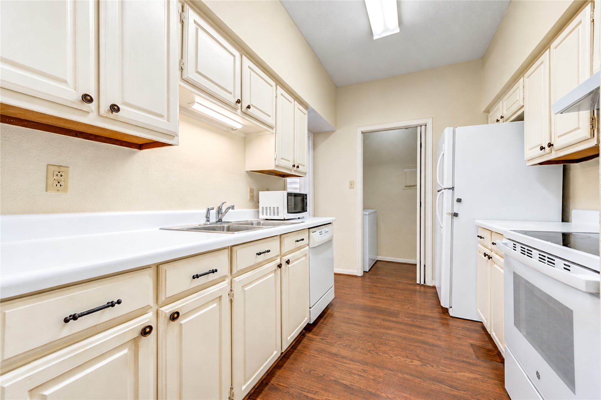 Charming kitchen with classic cream cabinetry, modern electric stove, and convenient storage, offering a cozy and functional cooking space.