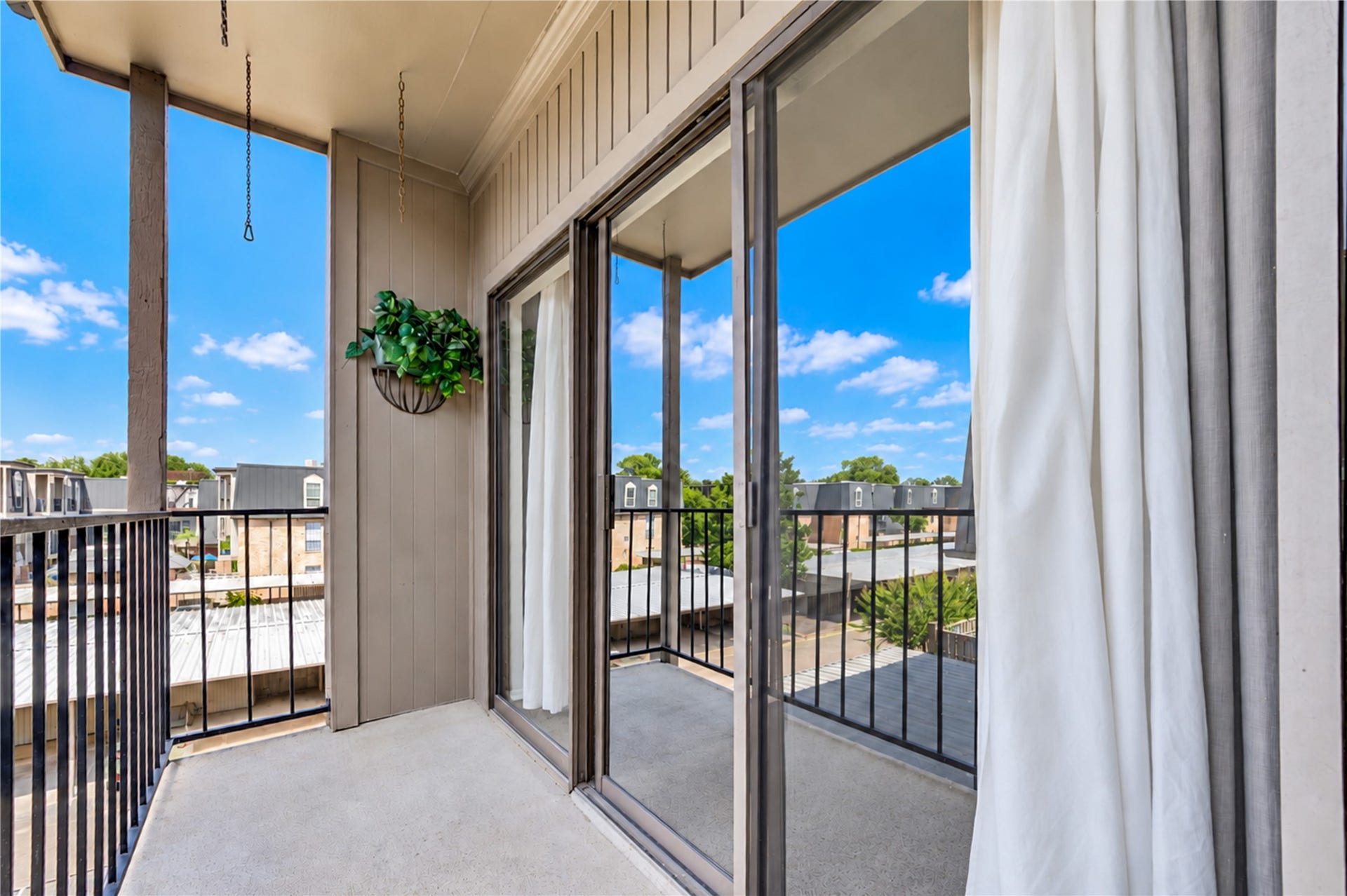 Charming brick patio with lush greenery offers a cozy outdoor retreat, adjacent to convenient covered parking.