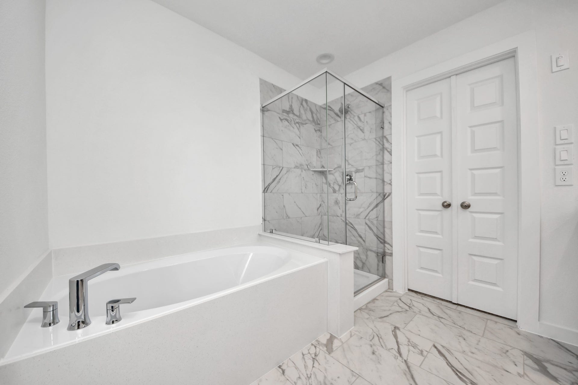 14702 Freestone Plum Court, Houston, TX 77049 Escape to a spa-like oasis in this primary bathroom. Enjoy a walk-in shower with tile surround, a separate garden tub with custom detailing, and an elegant vanity featuring light countertops, modern hardware, and beautiful recessed lights. Experience luxury and relaxation in every detail. Sample photo of completed home with similar floor plan. Actual colors and selections may vary.