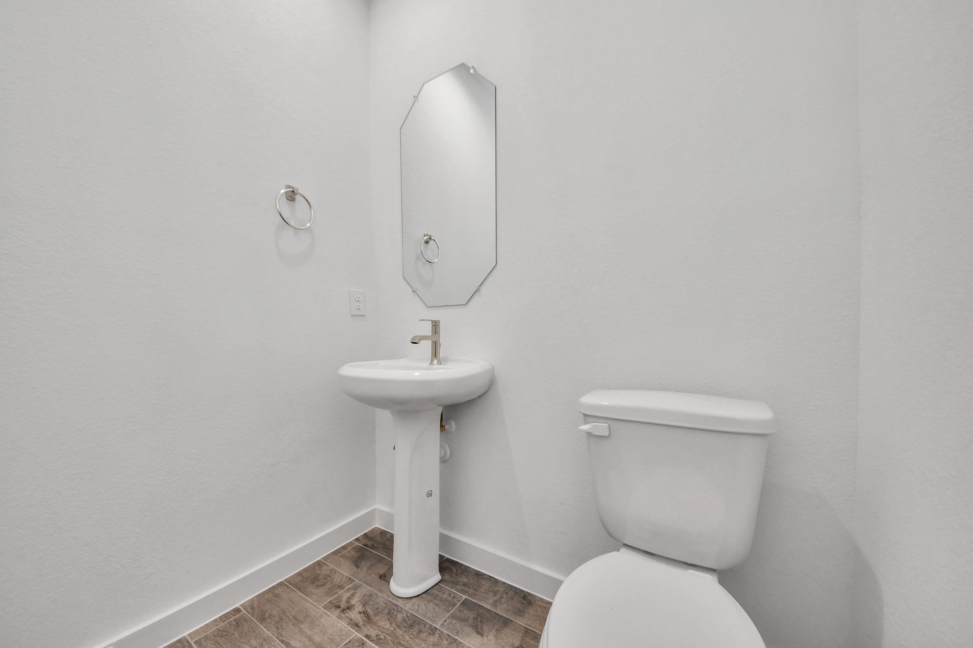 14702 Freestone Plum Court, Houston, TX 77049 This half bathroom features a stylish pedestal sink, modern hardware, and bright recessed lighting, creating a sleek and inviting space. Sample photo of completed home with similar floor plan. Actual colors and selections may vary.