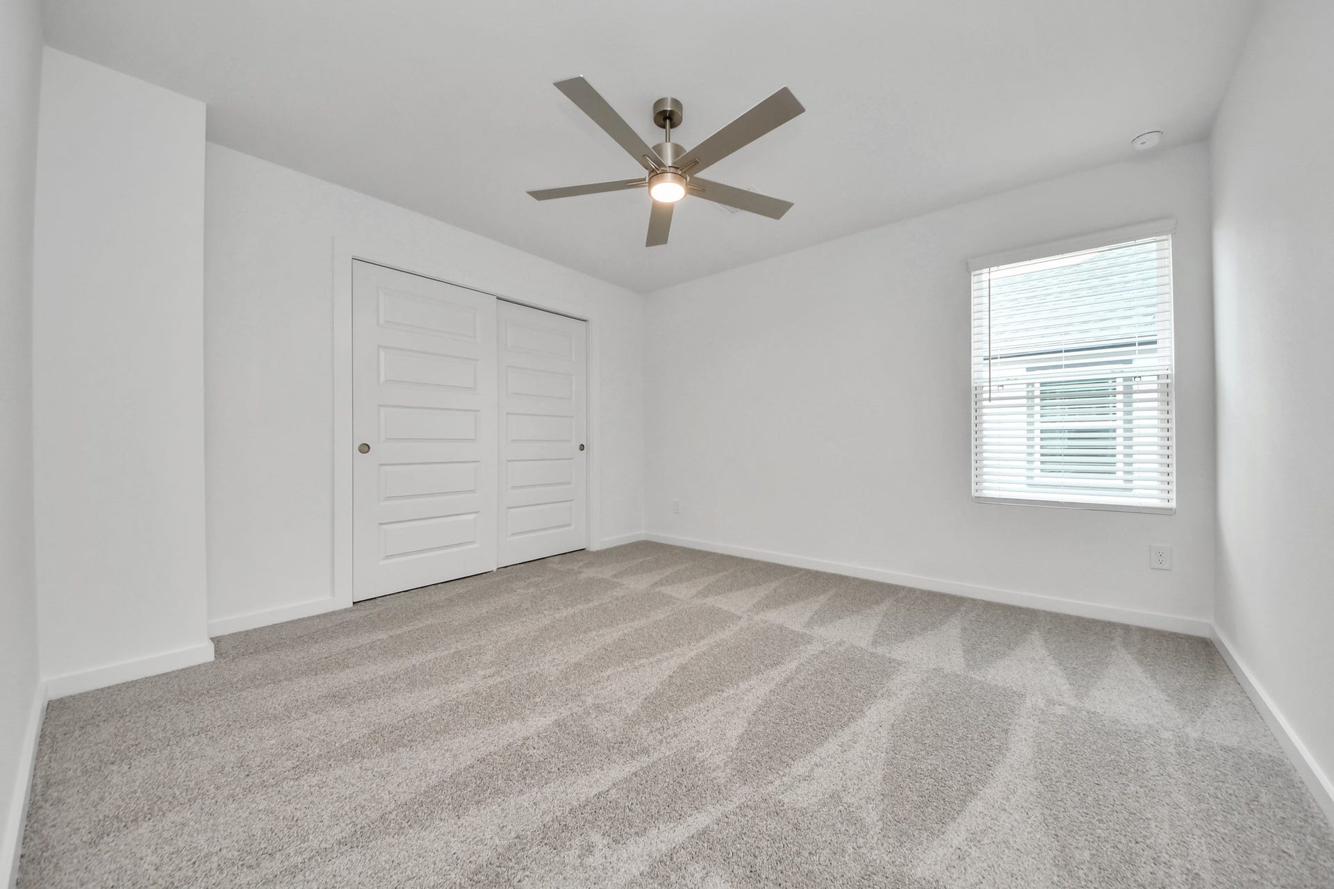 14702 Freestone Plum Court, Houston, TX 77049 Secondary bedroom features plush carpeting, large windows that let in plenty of natural light, bright paint, and spacious closets. Sample photo of completed home with similar floor plan. Actual colors and selections may vary.
