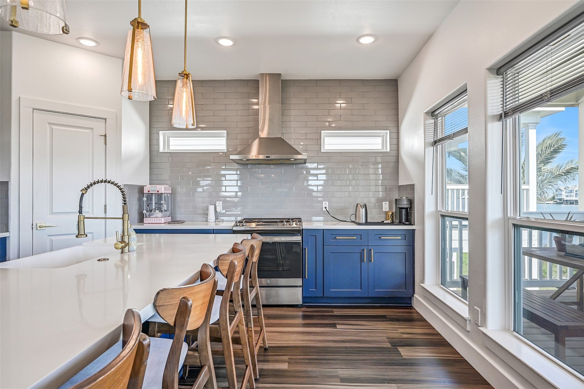 3627 Niko Court, Galveston, TX 77554 The kitchen showcases beautiful quartz countertops, elegant gold accents, and blue soft-close cabinetry throughout.