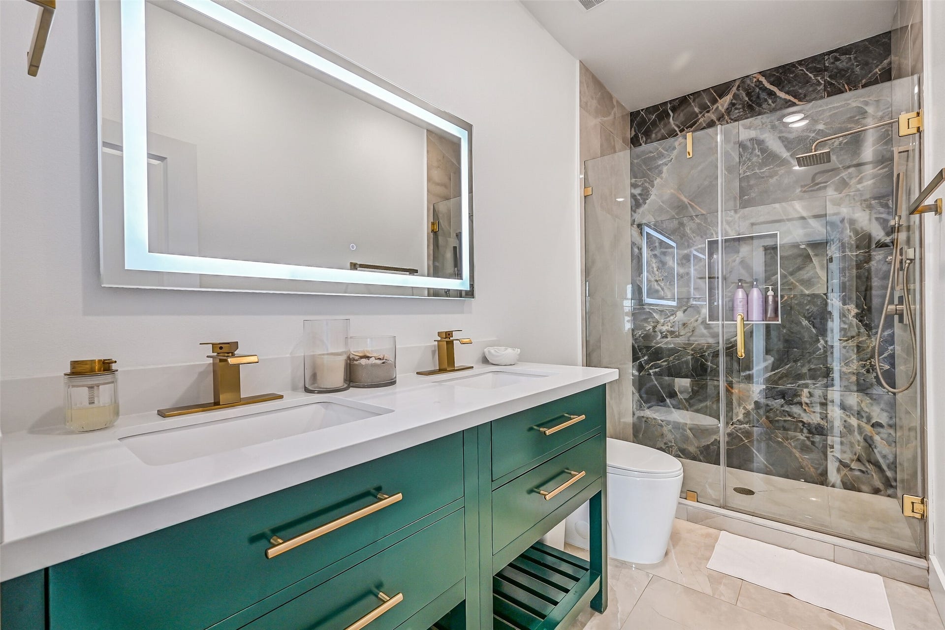 3627 Niko Court, Galveston, TX 77554 Just across the hall, youll find a similarly designed bathroom featuring elegant gold fixtures, double vanities, and a walk-in shower with stunning dark tile and a waterfall showerhead.