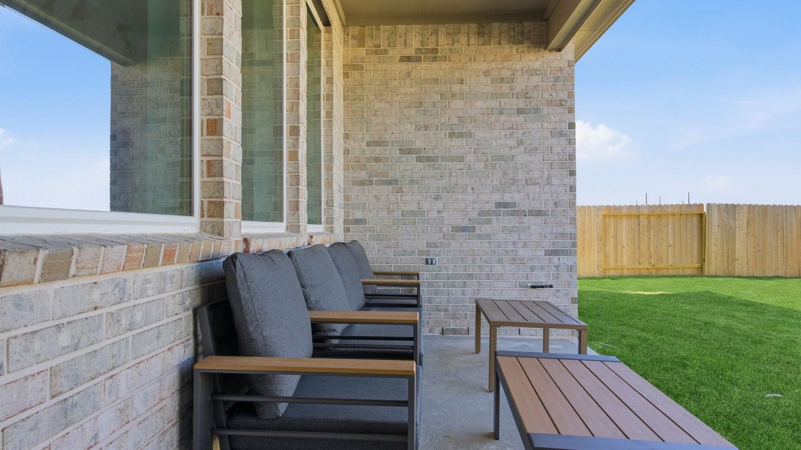 2507 Friendswood Trail, Friendswood, TX 77546 Outdoor covered patio with seating area overlooking a well-maintained lawn, perfect for relaxation.