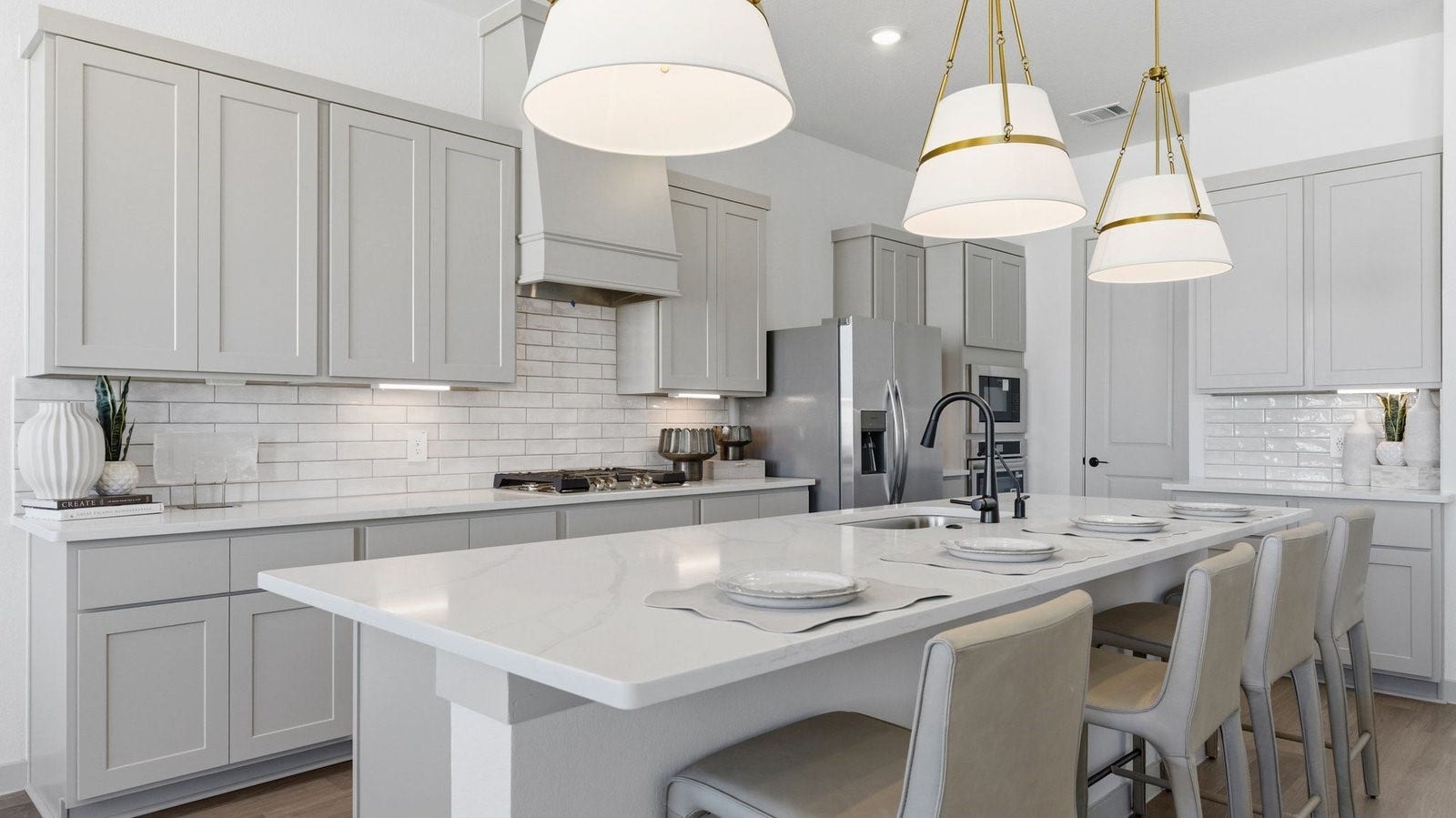 2507 Friendswood Trail, Friendswood, TX 77546 Luxurious and spacious kitchen with quartz countertops, stainless steel appliances, painted cabinets, expansive storage and an island with bar seating.