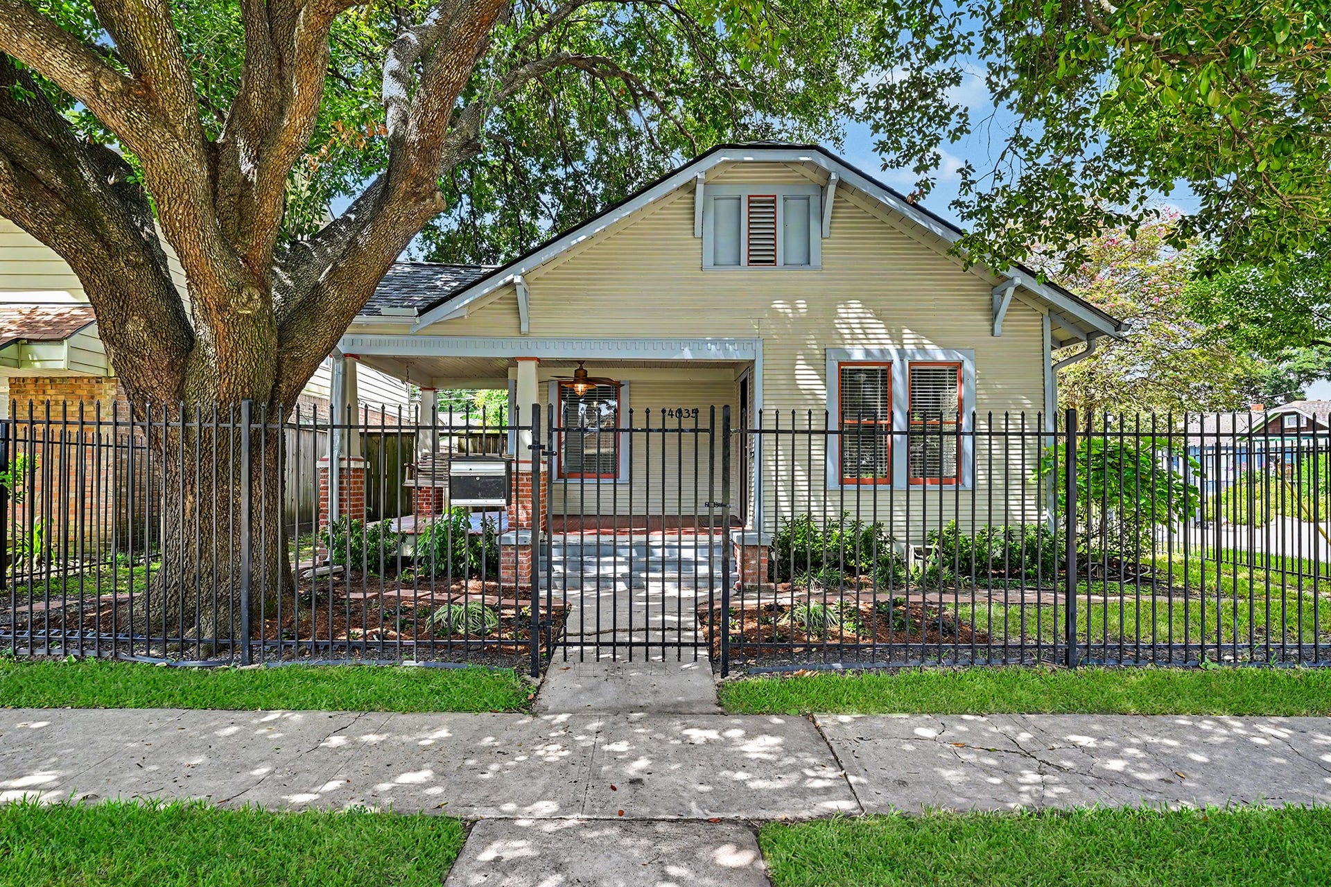 Classic Heights bungalow on a fenced and gated corner lot framed by mature trees and exceptional curb appeal.