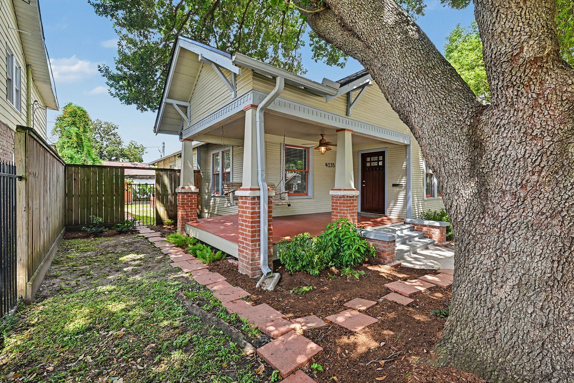 Charming front porch with a swing and ceiling fan creates an inviting spot to relax and enjoy the outdoors.