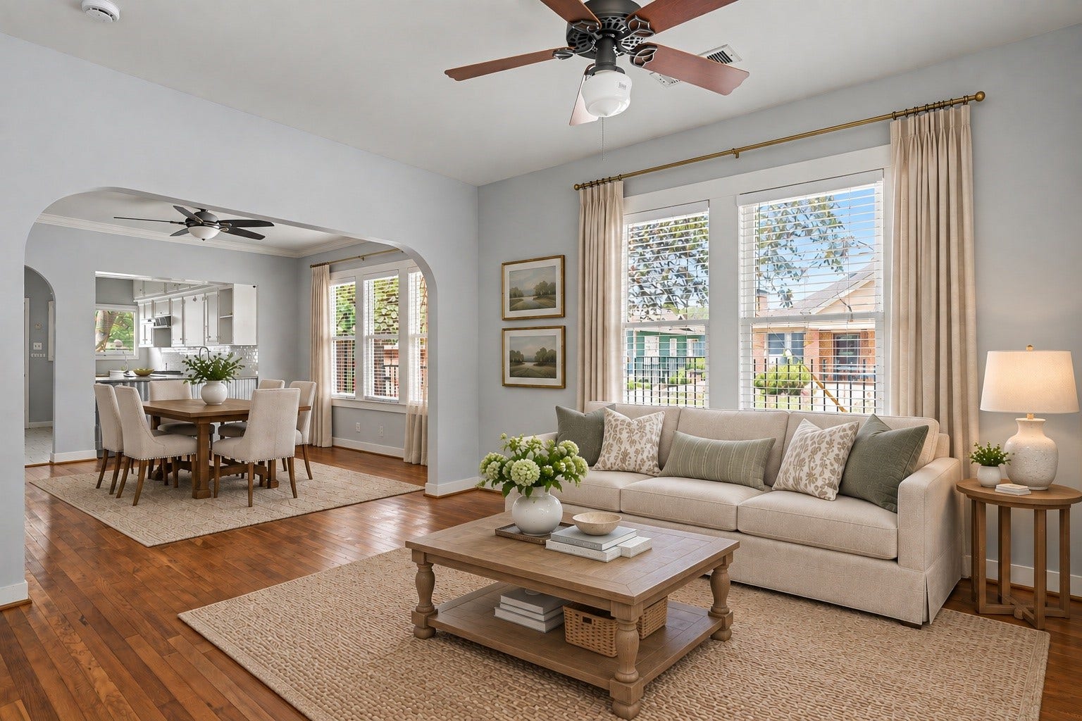 Large living room, virtually staged, opens into the dining room through an arched doorway.