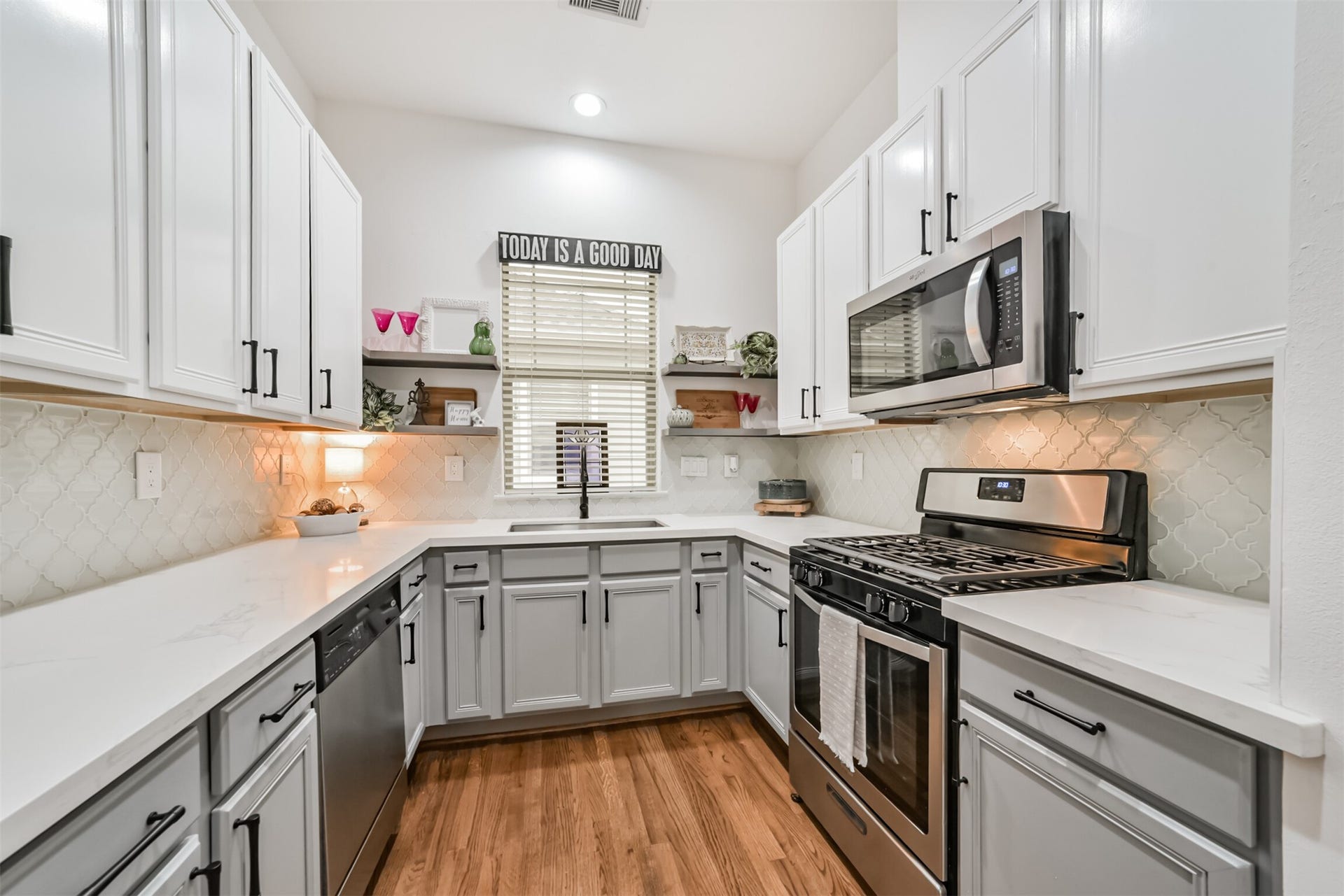 1721 W 24th Street, Houston, TX 77008 Bright, beautifully remodeled kitchen boasting quartzite counters, designer tile backsplash, stainless appliances, and charming open shelving