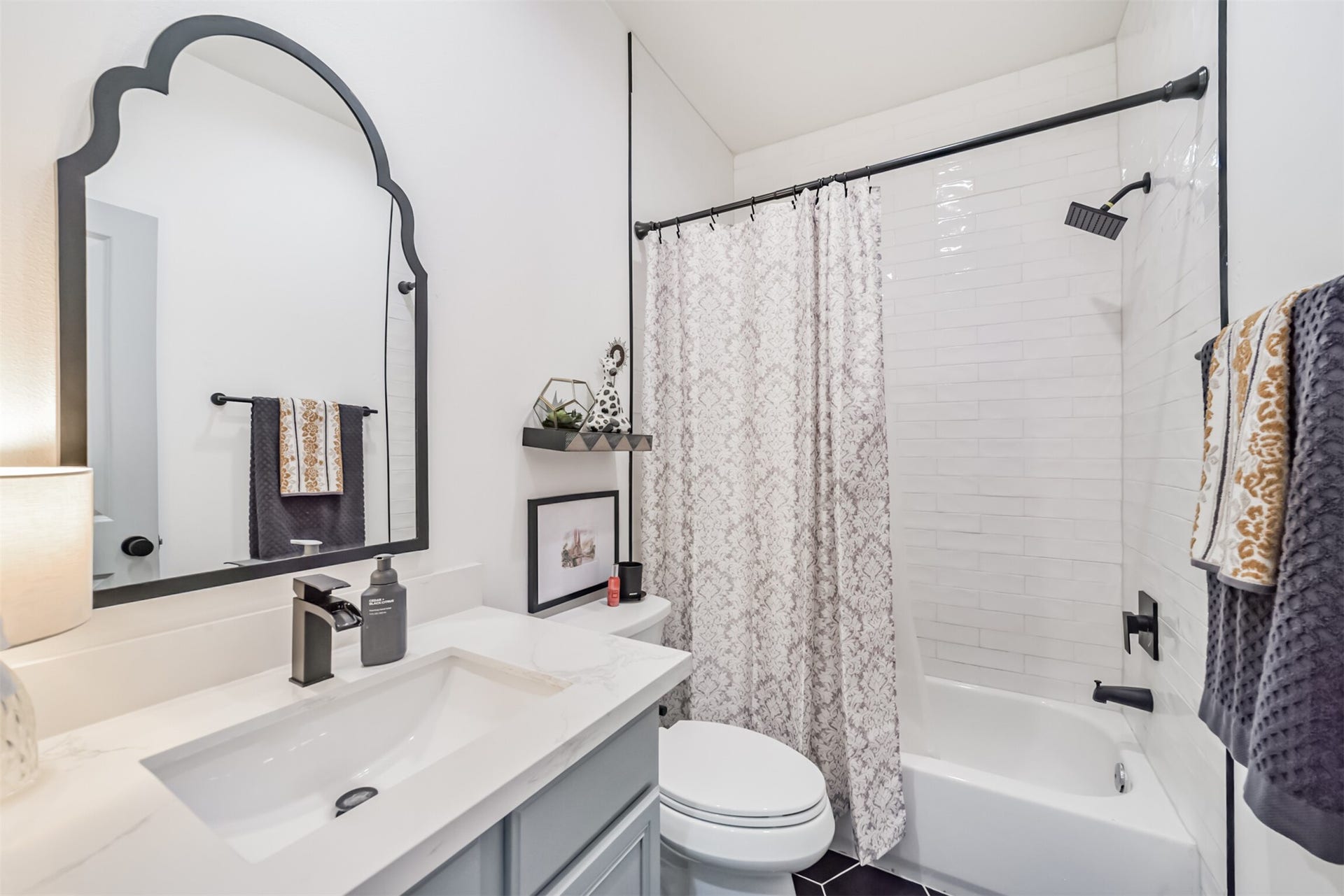 1721 W 24th Street, Houston, TX 77008 Secondary bathroom features lovely mirror, artisan-tile surround and hexagonal tile floors.